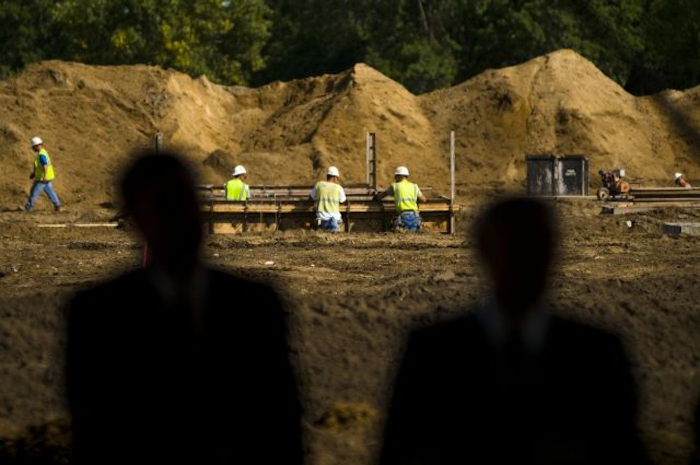 Beyond the silhouettes of Congressman Erik Paulsen of the 3rd District, and Molasky Group of Companies Chairman Irwin Molasky, work continued on the FBI building on Tuesday.