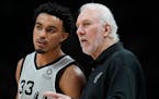 Apple Valley’s Tre Jones (talking with San Antonio coach Gregg Popovich during an Oct. 22 game) is averaging 2.9 points and 1.1 assists for the Spur