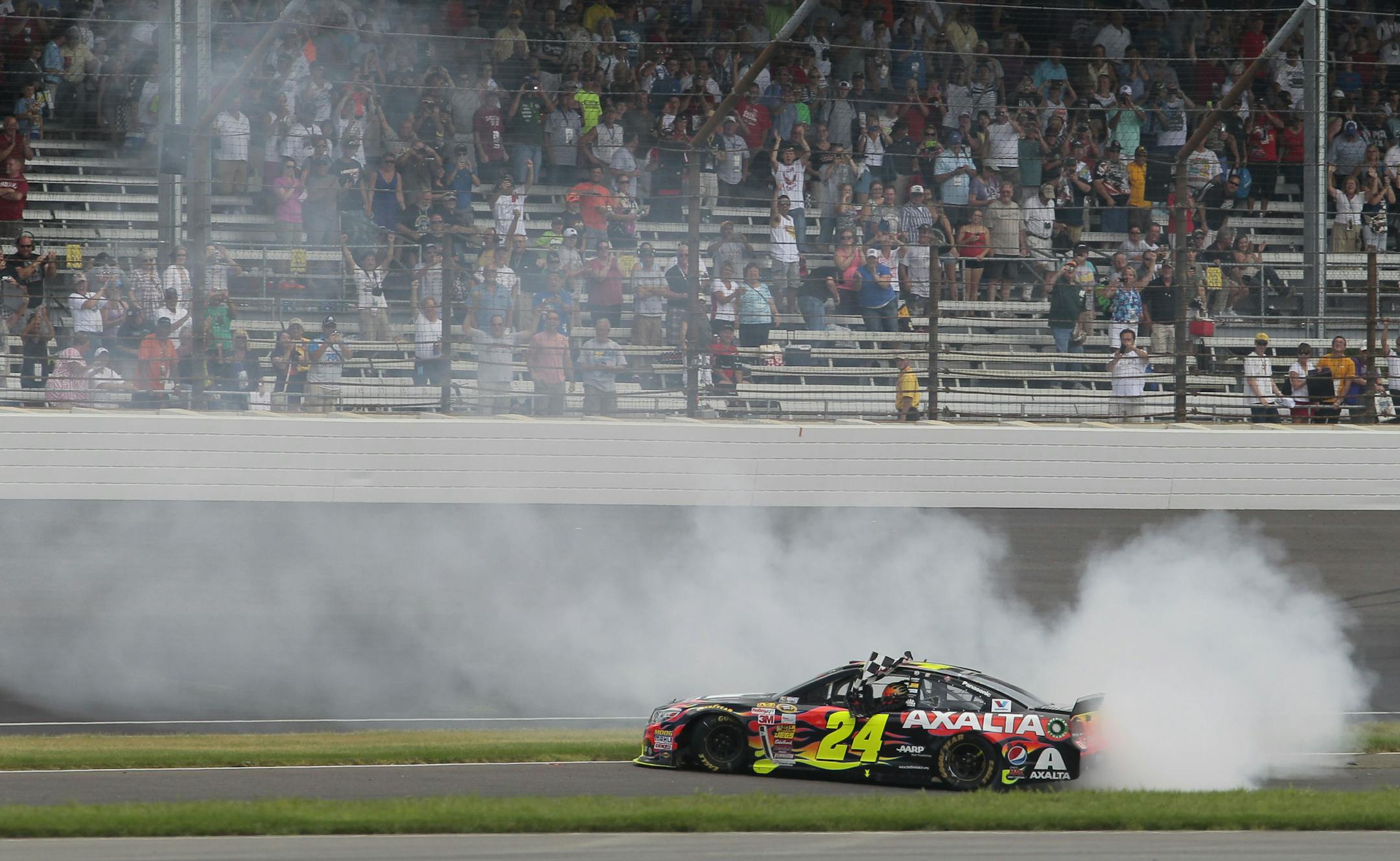 Jeff Gordon celebrates by doing a burn out in the first turn after winning the NASCAR Brickyard 400 auto race at Indianapolis Motor Speedway in Indianapolis, Sunday, July 27, 2014. (AP Photo/Bill Friel)