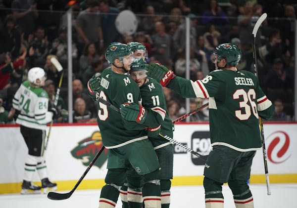Minnesota Wild left wing Zach Parise (11) was congratulated by his linemates, including Minnesota Wild center Mikko Koivu (9) and defenseman Nick Seel