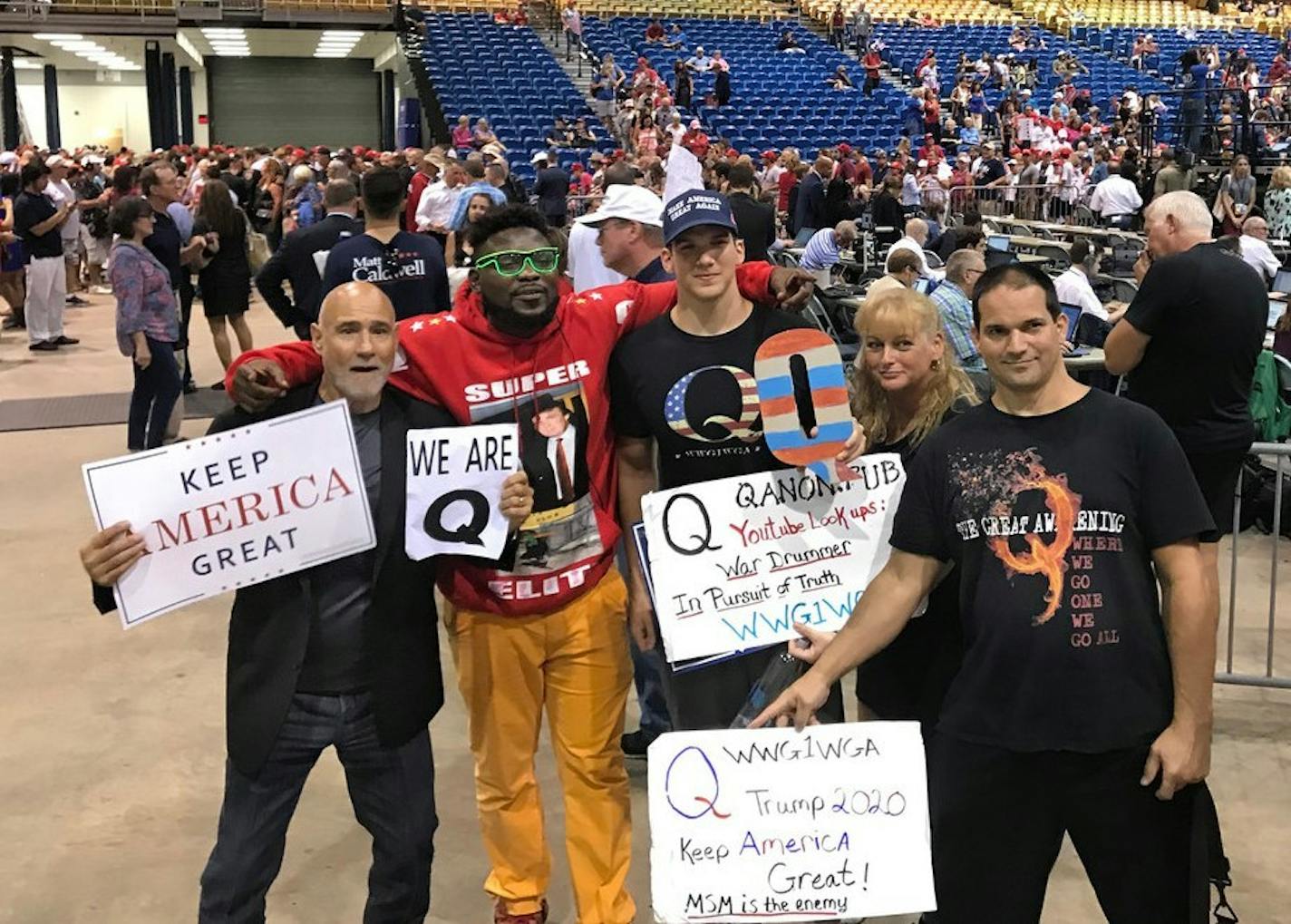 Donald Trump supporters who are proponents of the "QAnon" conspiracy theory pose for a photo after Trump spoke at a MAGA rally at the Florida State Fairgrounds on Tuesday, July 31, 2018 in Tampa, Fla.