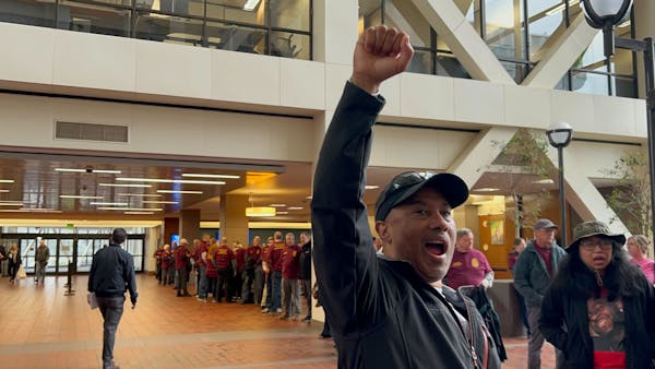A man raises his fist demanding justice for Ricky Cobb II as supporters of Trooper Ryan Londregan look on at the Hennepin County Government Center Mon