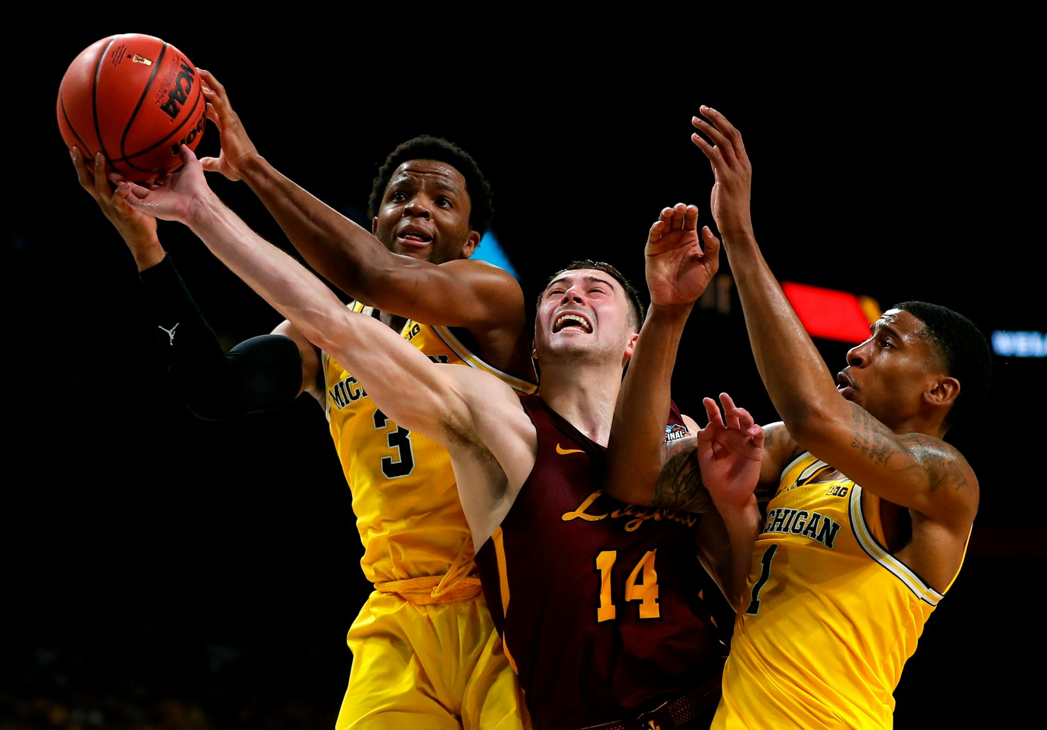 Loyola-Chicago guard Ben Richardson (14) fights for a rebound with Michigan guard Zavier Simpson, left, and Charles Matthews, right, during the second half in the semifinals of the Final Four NCAA college basketball tournament, Saturday, March 31, 2018, in San Antonio. Michigan won 69-57. (AP Photo/Charlie Neibergall)