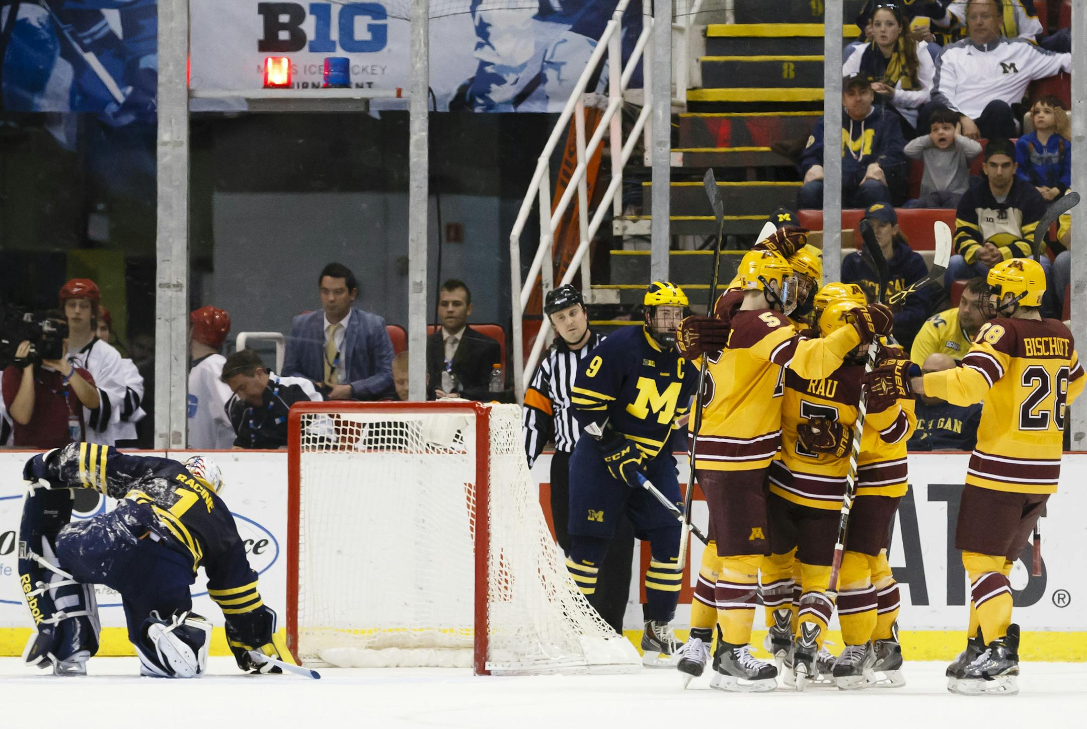Minnesota's Kyle Rau, center right, celebrates with teammates after scoring against Michigan's Steve Racine, left, in the second period during an NCAA college hockey game in the Big Ten Conference tournament Saturday, March 21, 2015, in Detroit. (AP Photo/Rick Osentoski)