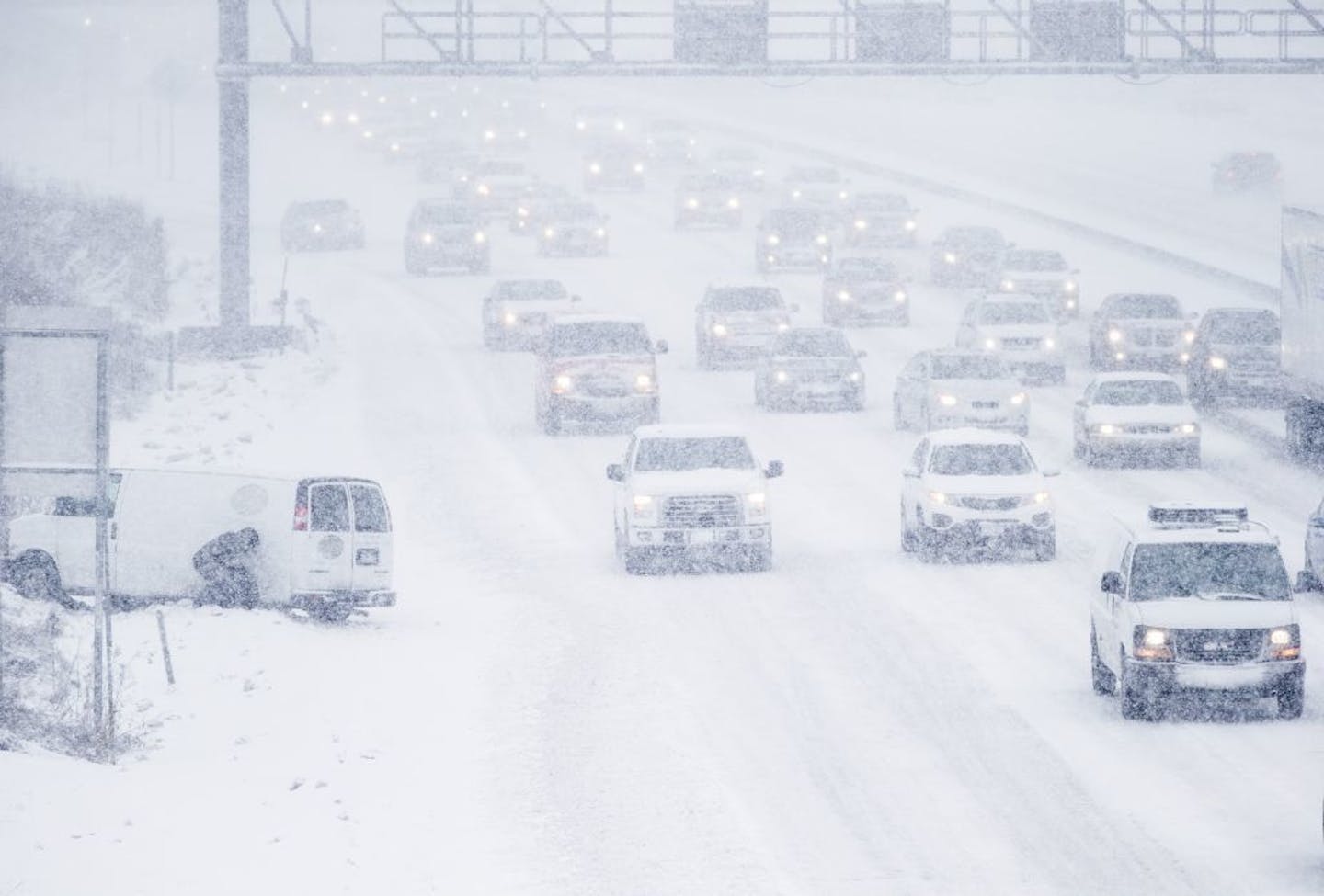 A person tried to dig out their tire after going off the road during traffic on southbound I-35W in Burnsville during Tuesday's snowstorm.