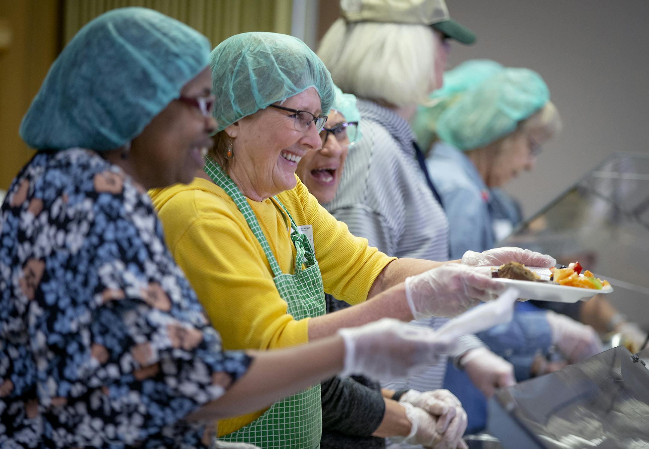 Volunteers handed out food to those who were in line at the Open Hands Midway food line, Monday, March 25, 2019 in St. Paul, MN Open Hands is housed at Bethlehem Lutheran Church, serves a meal to area homeless and poor residents. They also have a nurse on site and give away groceries and clothing. Organizers worry that the stadium development may squeeze these folks to stop showing up.