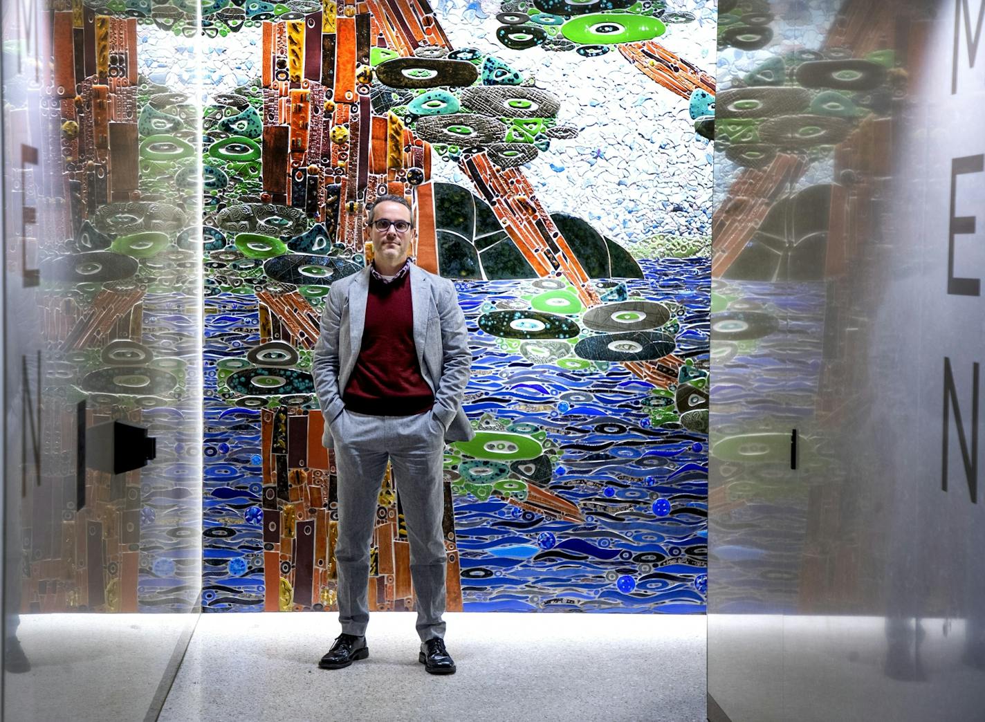 Ben Owen, director of Arts @ MSP, stood in front of "View of a Minnesota Lake," a ceramic tile work by Sheryl Tuorila at the entrance to one of the airport bathrooms.