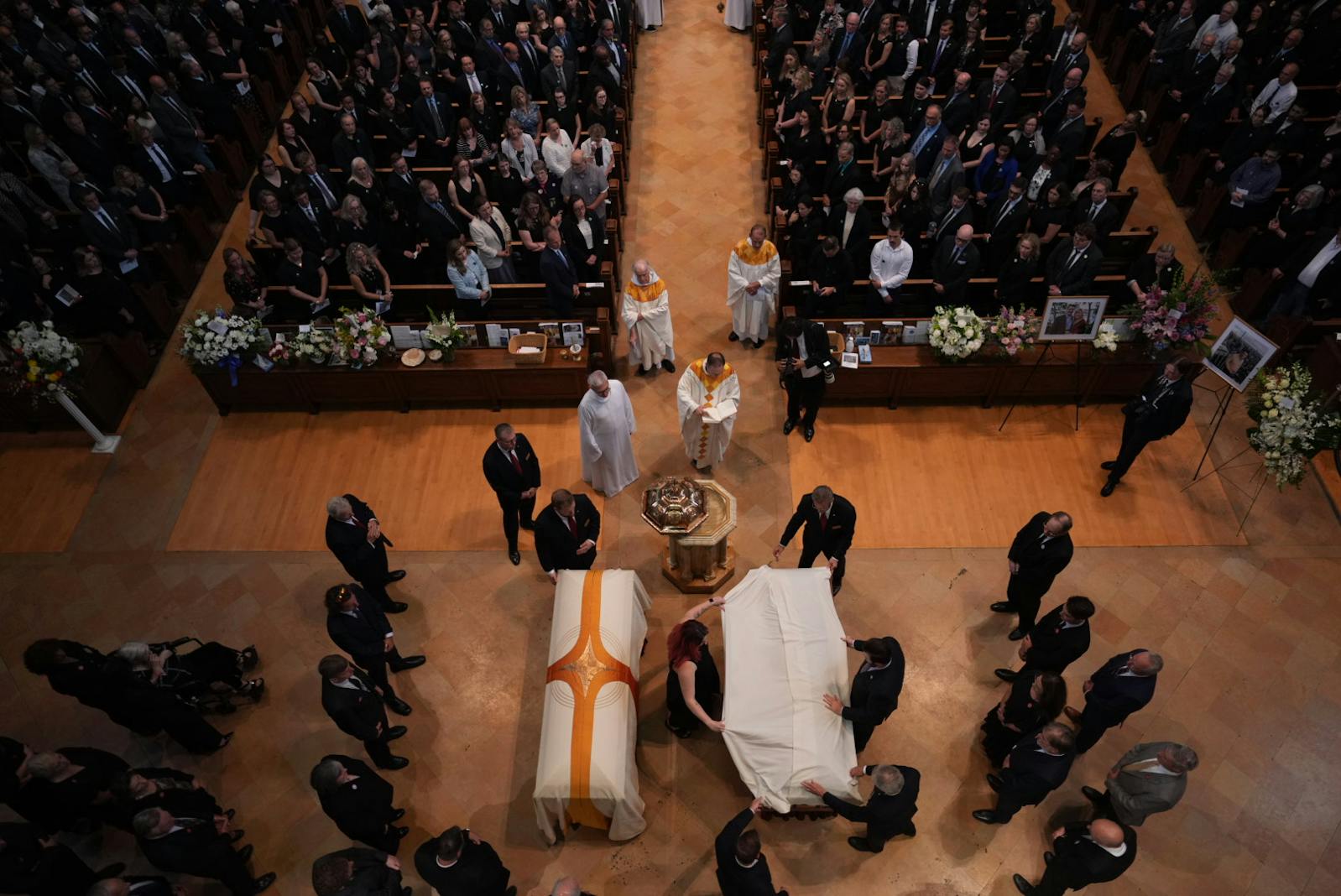 The caskets of Mellissa Hortman, left, and Mark Hortman, right, before they are processed down the aisle of the sanctuary during funeral services at the Basilica of St. Mary in Minneapolis.