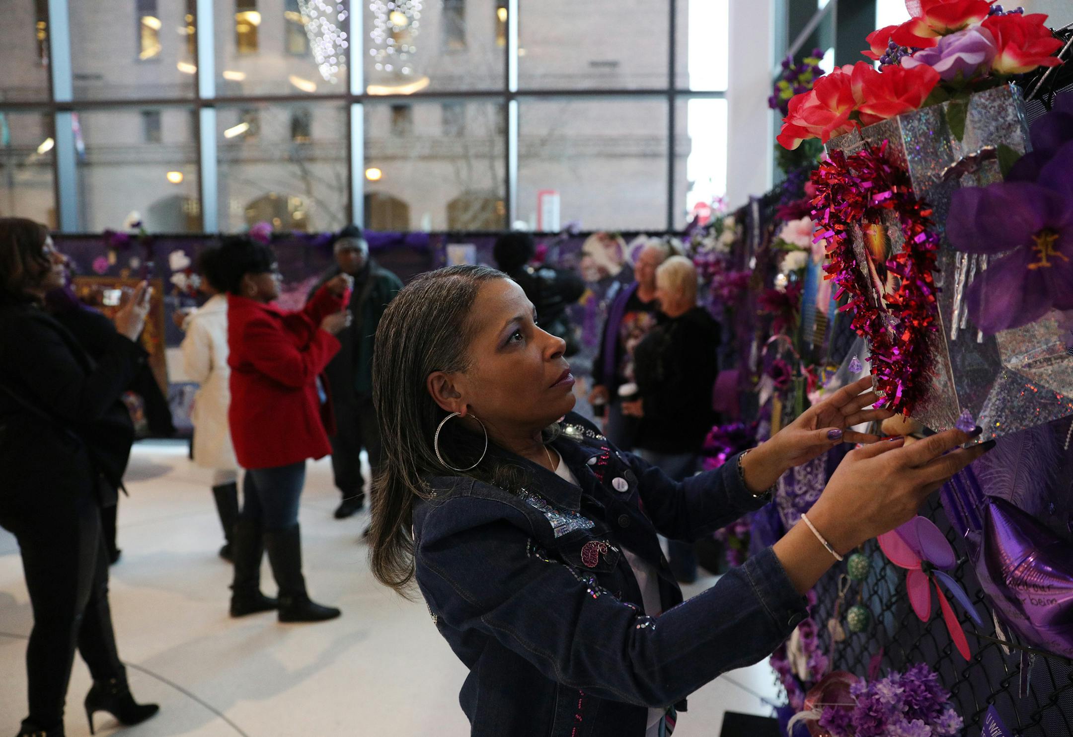 Prince fan Melissa Rassi of Detroit hung a bag of flowers at a section of the fence memorial constructed in the lobby of the Target Center prior to the start of Prince: Live on the Big Screen Friday. ] ANTHONY SOUFFLE ï anthony.souffle@startribune.com Fans gathered to see Prince: Live on the Big Screen Friday, April 20, 2018 at the Target Center in Minneapolis.