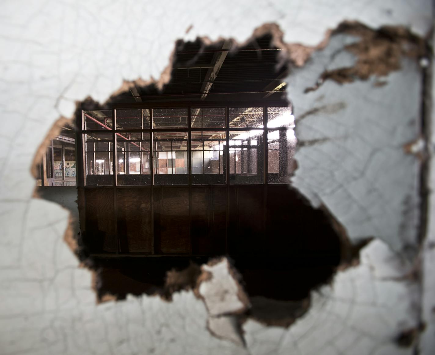 A hole in the wall showed another room of building 101 which was a manufacturing facility at the Twin Cities Army Ammunition Plant in Arden Hills, Minn., on Tuesday, June 18, 2013. ] (RENEE JONES SCHNEIDER * reneejones@startribune.com)