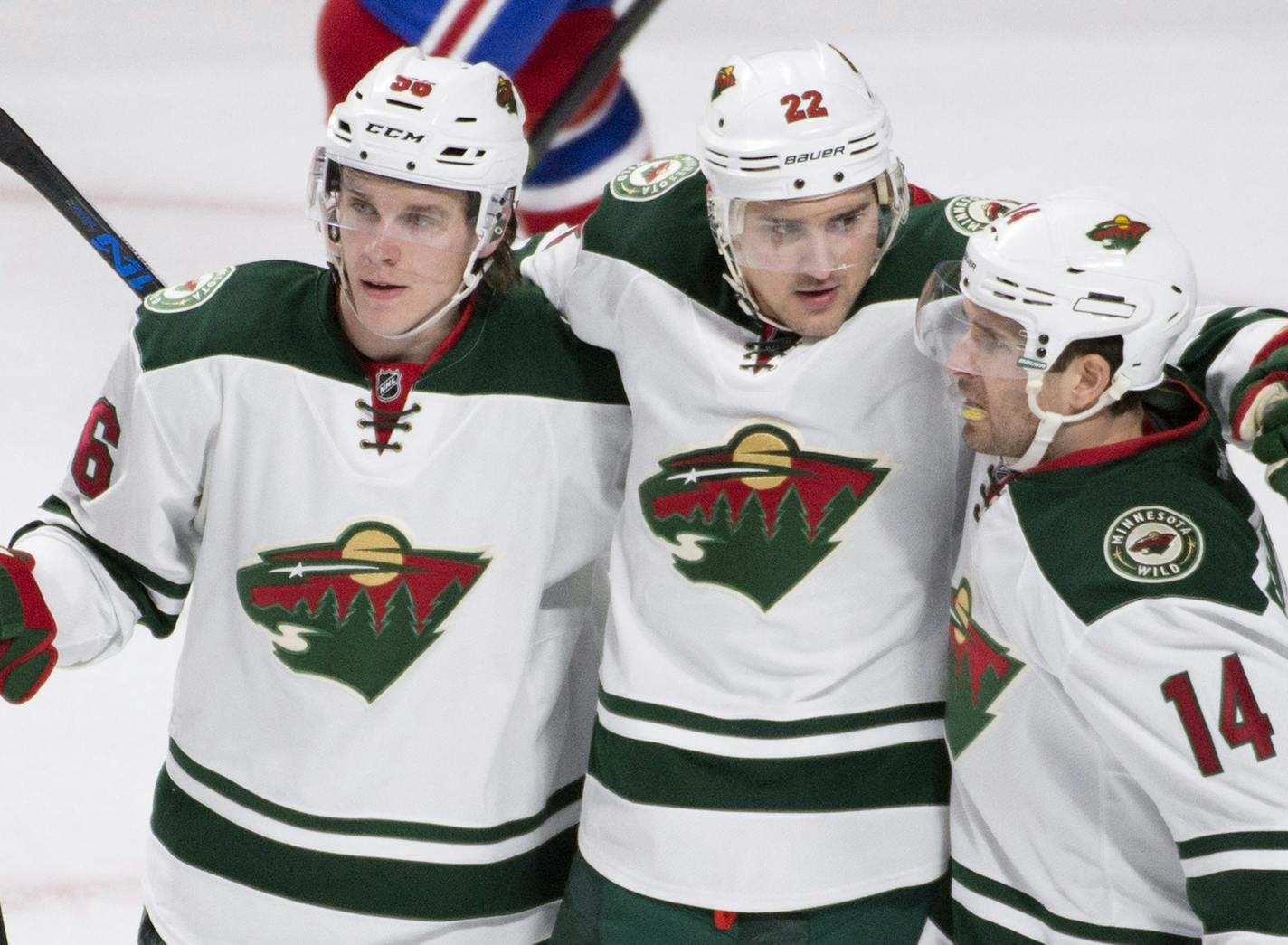 Minnesota Wild's Nino Niederreiter (22) celebrates with teammates Erik Haula (56) and Justin Fontaine (14) after scoring against the Montreal Canadiens during the first period of an NHL hockey game in Montreal on Saturday, March 12, 2016. (Graham Hughes /The Canadian Press via AP) MANDATORY CREDIT