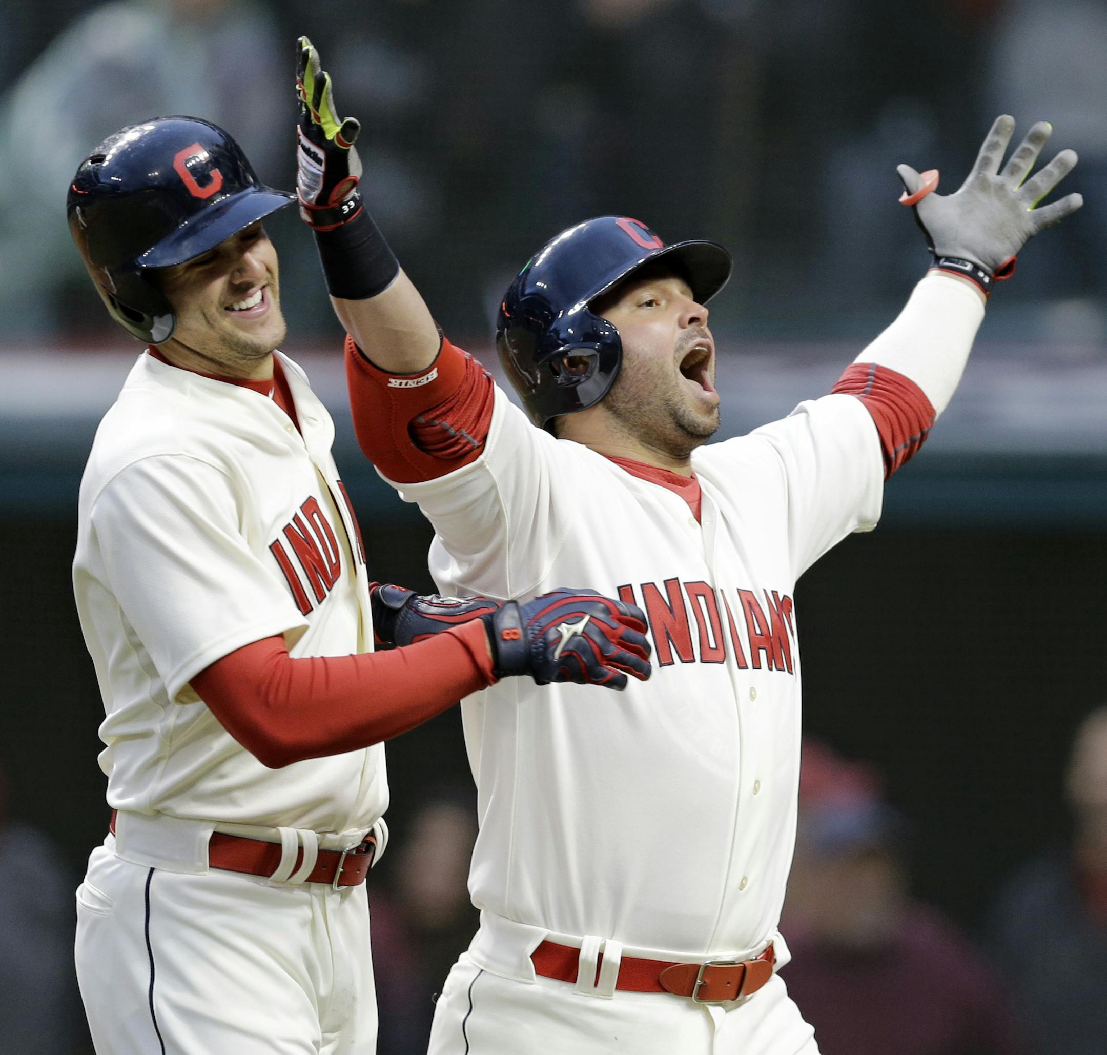 Cleveland Indians' Nick Swisher, right, looks to the fans as he celebrates with Lonnie Chisenhall after Swisher hit a two-run home run off Minnesota Twins starting pitcher Mike Pelfrey in the sixth inning of a baseball game, Friday, April 4, 2014, in Cleveland. Chisenhall scored. (AP Photo/Mark Duncan)