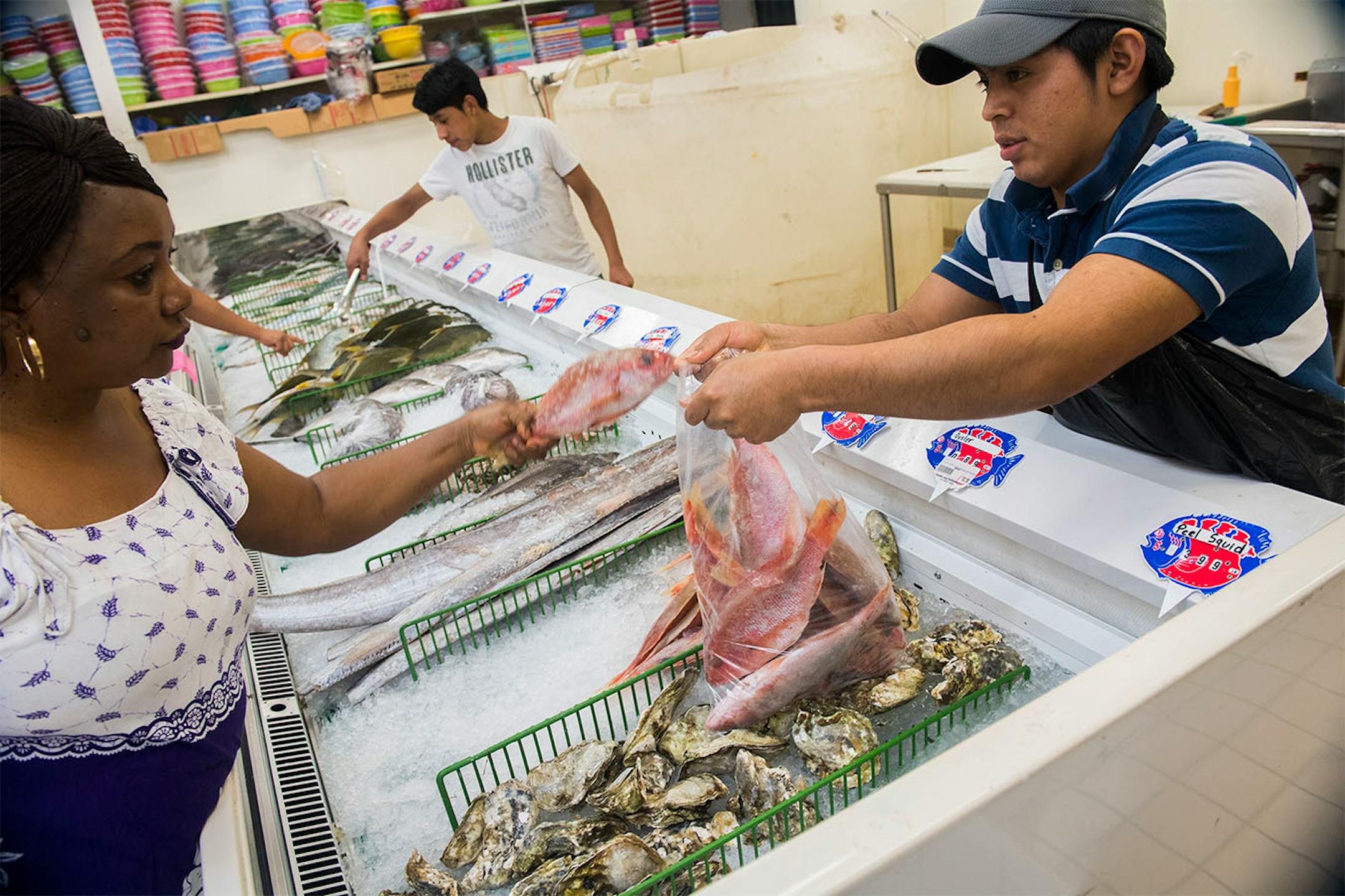 Jaja Barry, left, received a bag of fish she purchased from Lester Lucas-Huinil at Shuang Hur grocery located at 2712 Nicollet Avenue.
