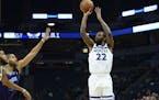 Minnesota Timberwolves forward Andrew Wiggins (22) hit a 3-pointer under pressure in the first half against the Charlotte Hornets. ] Aaron Lavinsky &#
