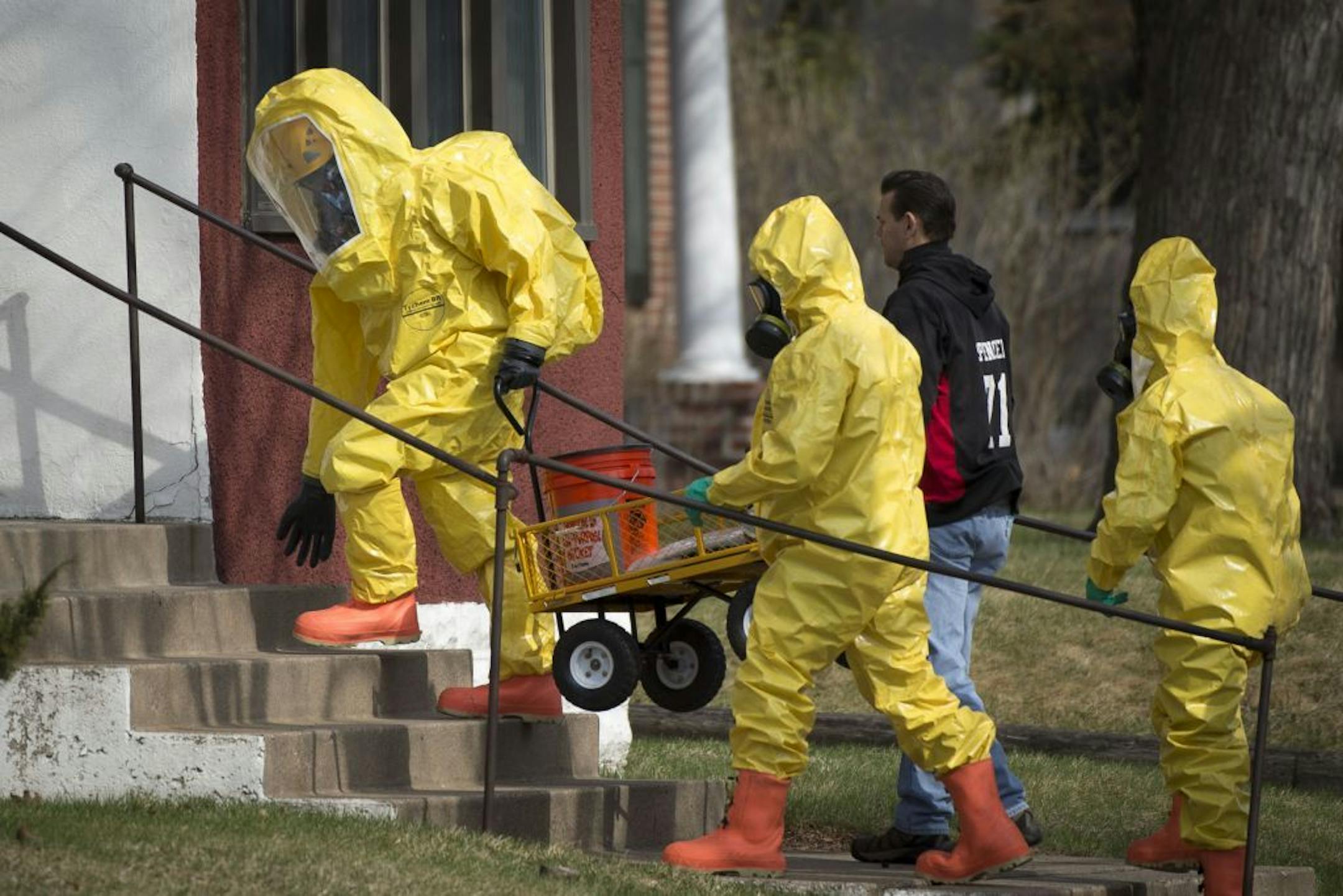 Hazardous material workers enter an apartment complex on the 500 block of 6th Street Southeast on Friday, April 10, 2015.