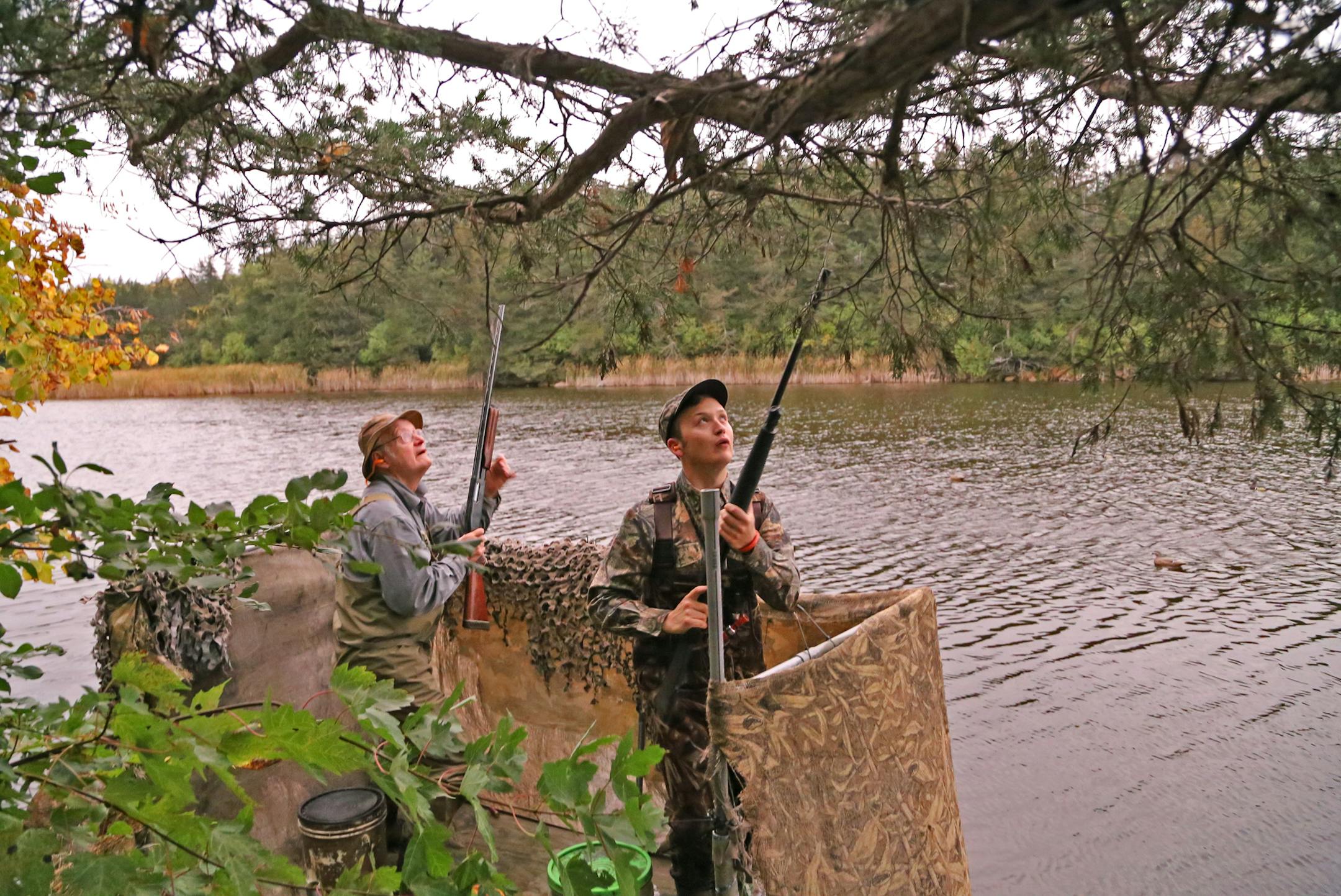 Will Smith, left, of Willmar, and his son Matthew, a student at South Dakota State University, track a pair of Canada geese that flew over their blind in the Minnesota River Valley backwaters on Saturday morning, opening of the 2017 waterfowl season.