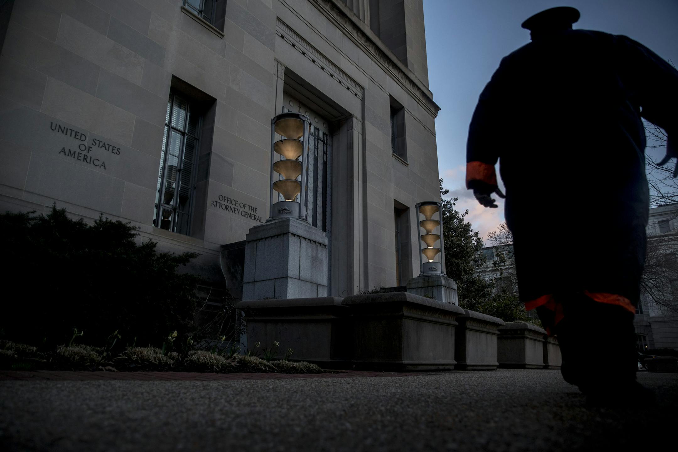 A security officer walks past the Department of Justice in Washington, Friday, March 22, 2019. Special counsel Robert Mueller has concluded his investigation into Russian election interference and possible coordination with associates of President Donald Trump. The Justice Department says Mueller delivered his final report to Attorney Barr, who is reviewing it. (AP Photo/Andrew Harnik)
