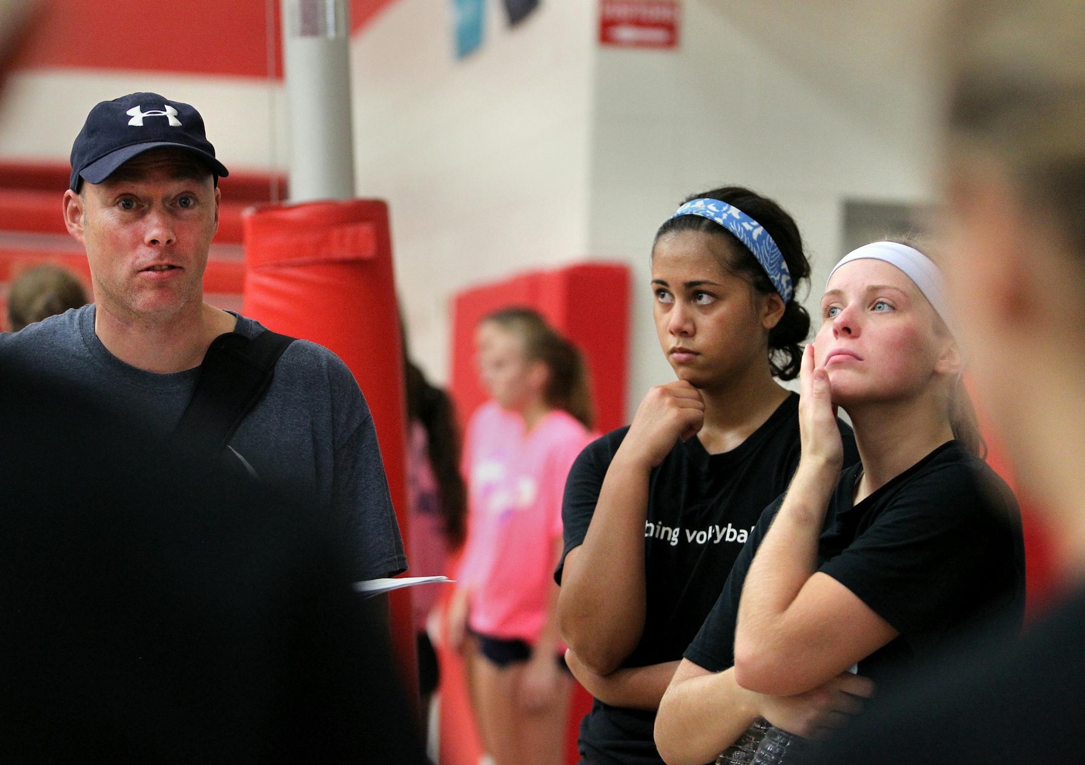Payton De La Cruz, center, and Taylor Schile, right, both seniors at Eastview High School listen as their head coach Ted Reiff speaks to the team after a volleyball scrimmage at North St. Paul High School in North St. Paul, Minn., on Tuesday, August 20, 2013. ] (ANNA REED/STAR TRIBUNE) anna.reed@startribune.com (cq)