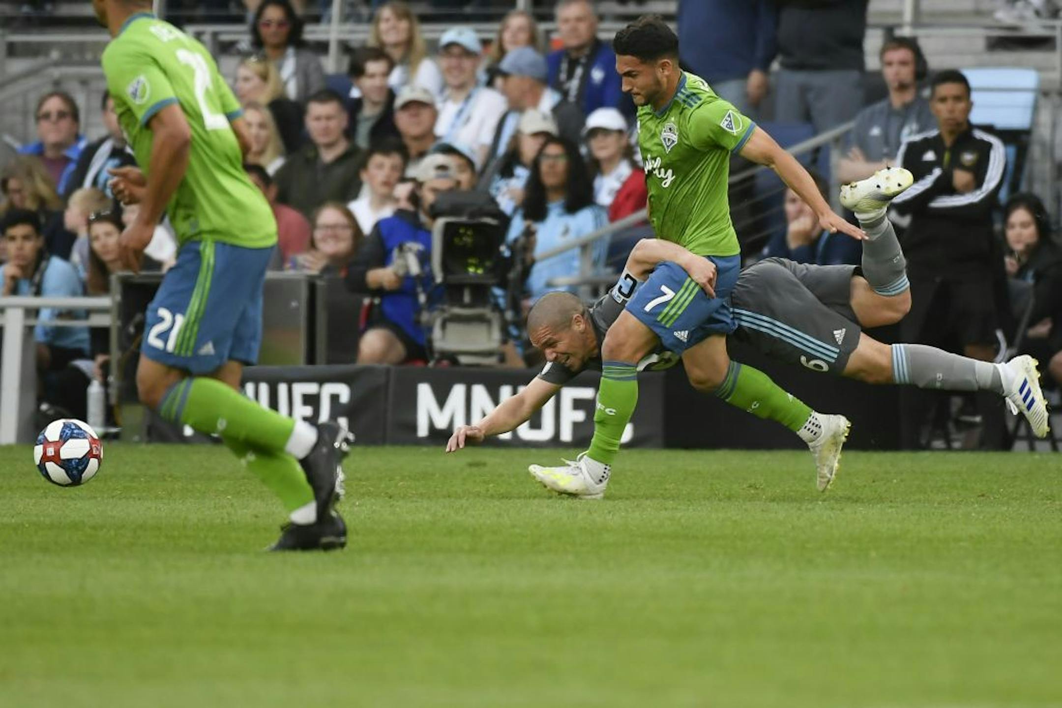 Minnesota United midfielder Osvaldo Alonso (6) fell to the pitch as he was challenged for the ball by Seattle Sounders midfielder Cristian Roldan (7) in the first half.