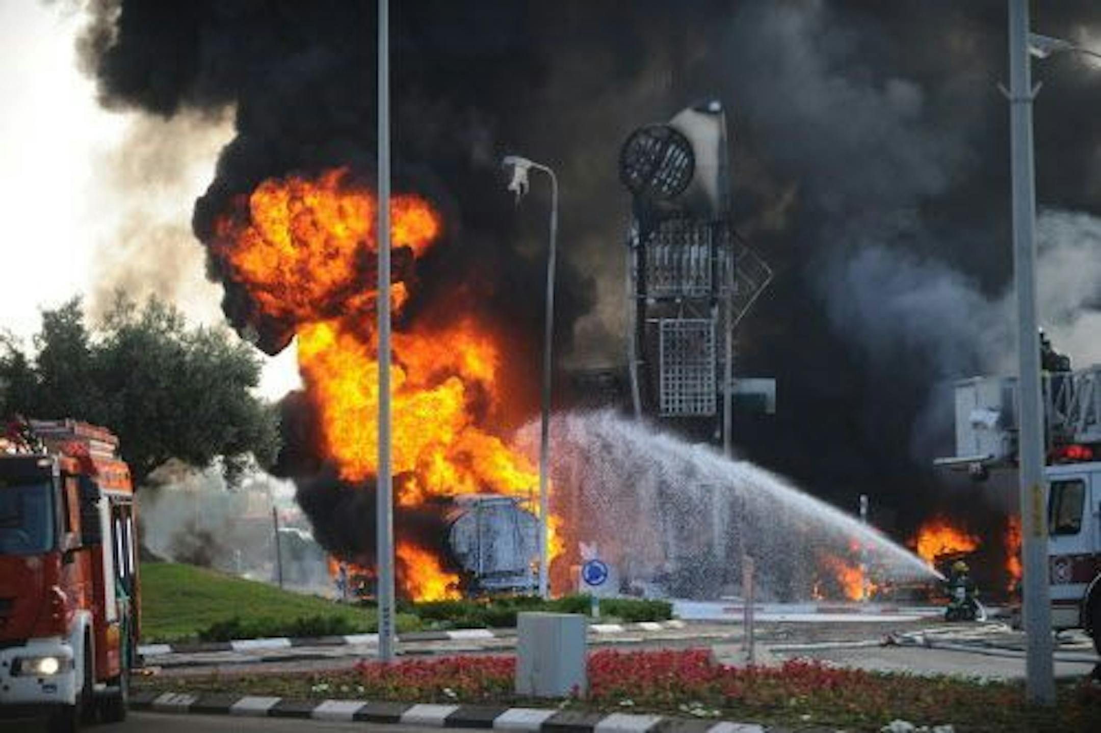 An Israeli firefighter tries to extinguish a petrol station on fire after it was hit by a rocket fired from Gaza in Ashdod, Israel, Friday, July 11, 2014.
