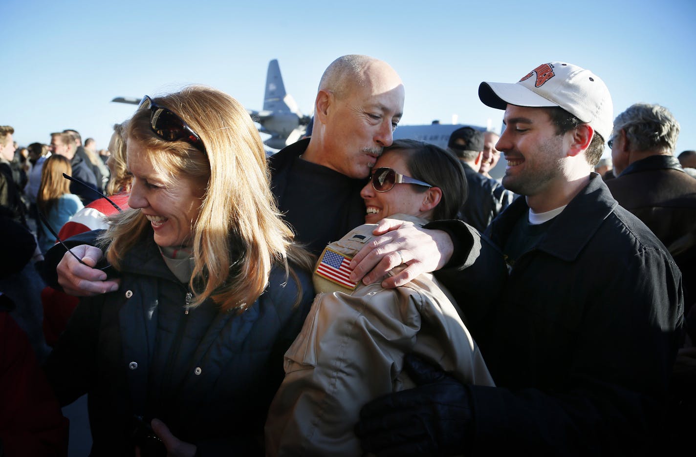 Jim Perry (center) hugged his daughter Lt. Alicia Makoutz , his wife Lori Perry left and Alicia husband Chris Makoutz looked on. Families gather for the arrival of the more than 100 Airmen and three C-130 H3 Hercules aircraft from the 934th Airlift Wing, Air Force Reserve, return from their deployment to Southwest Asia after their four-month tour of duty. Sunday January 18, 2015 Minneapolis, MN.] Jerry Holt/ Jerry.Holt@Startribune.com
