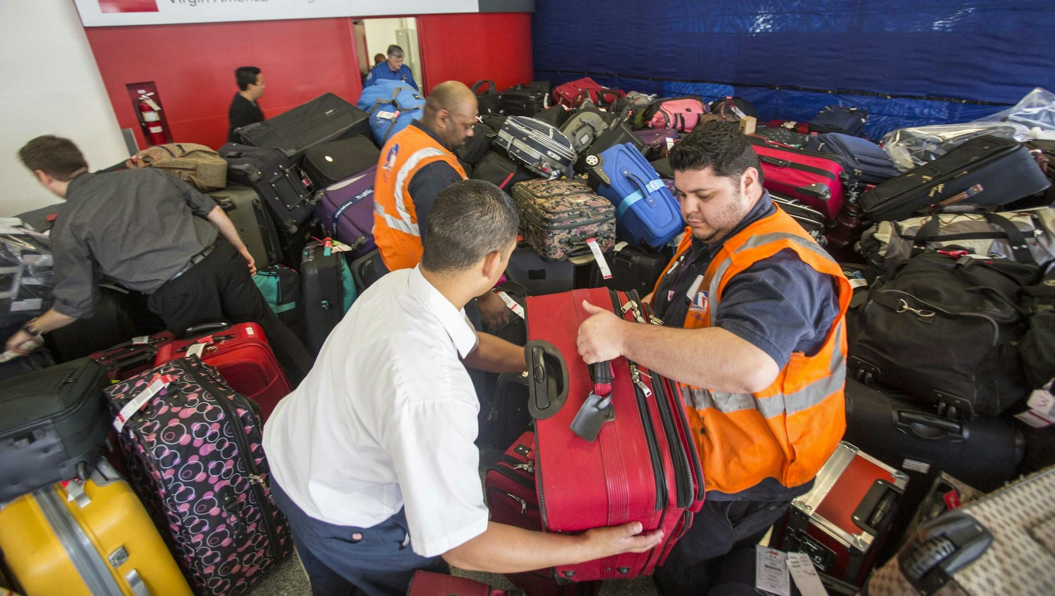 Transportation Security Administration employees classify the luggage to return to passengers at Los Angeles International Airport's Terminal 3 on Saturday, Nov. 2, 2013. A gunman armed with a semi-automatic rifle opened fire at the airport on Friday, killing a Transportation Security Administration employee and wounding two other people in an attack that frightened passengers and disrupted flights nationwide. (AP Photo/Ringo H.W. Chiu) ORG XMIT: MIN2013110215091435