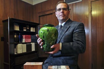 Gill Brothers funeral director Daniel McGraw, with an urn of unclaimed ashes.