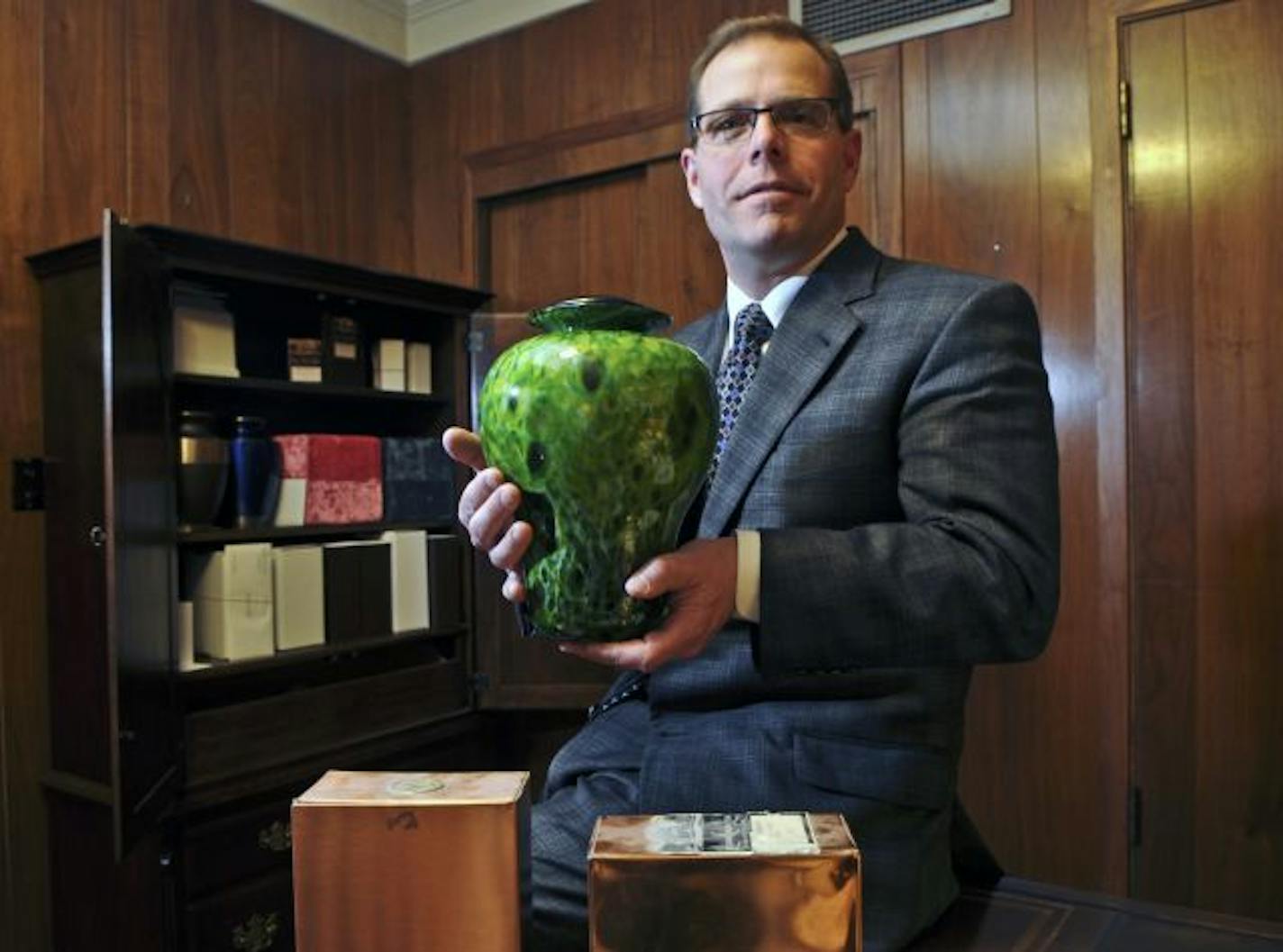 Gill Brothers funeral director Daniel McGraw, with an urn of unclaimed ashes.