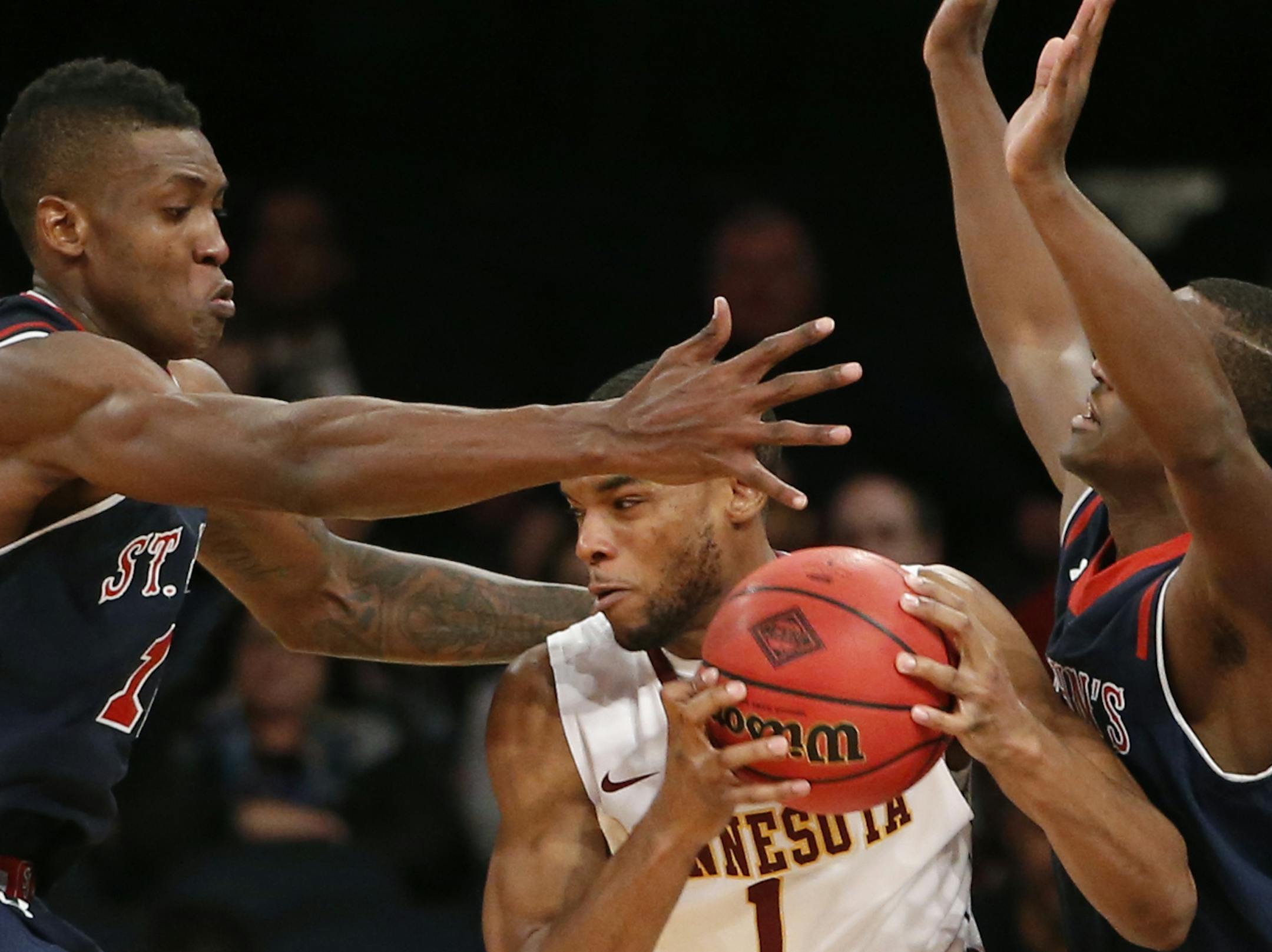 Minnesota guard Andre Hollins (1) is double-teamed by St. John's forward Chris Obekpa (12) and guard Phil Greene IV (1) in the second half of an NCAA college basketball game in New York, Wednesday, Nov. 26, 2014. St. John's defeated Minnesota 70-61. (AP Photo/Kathy Willens)