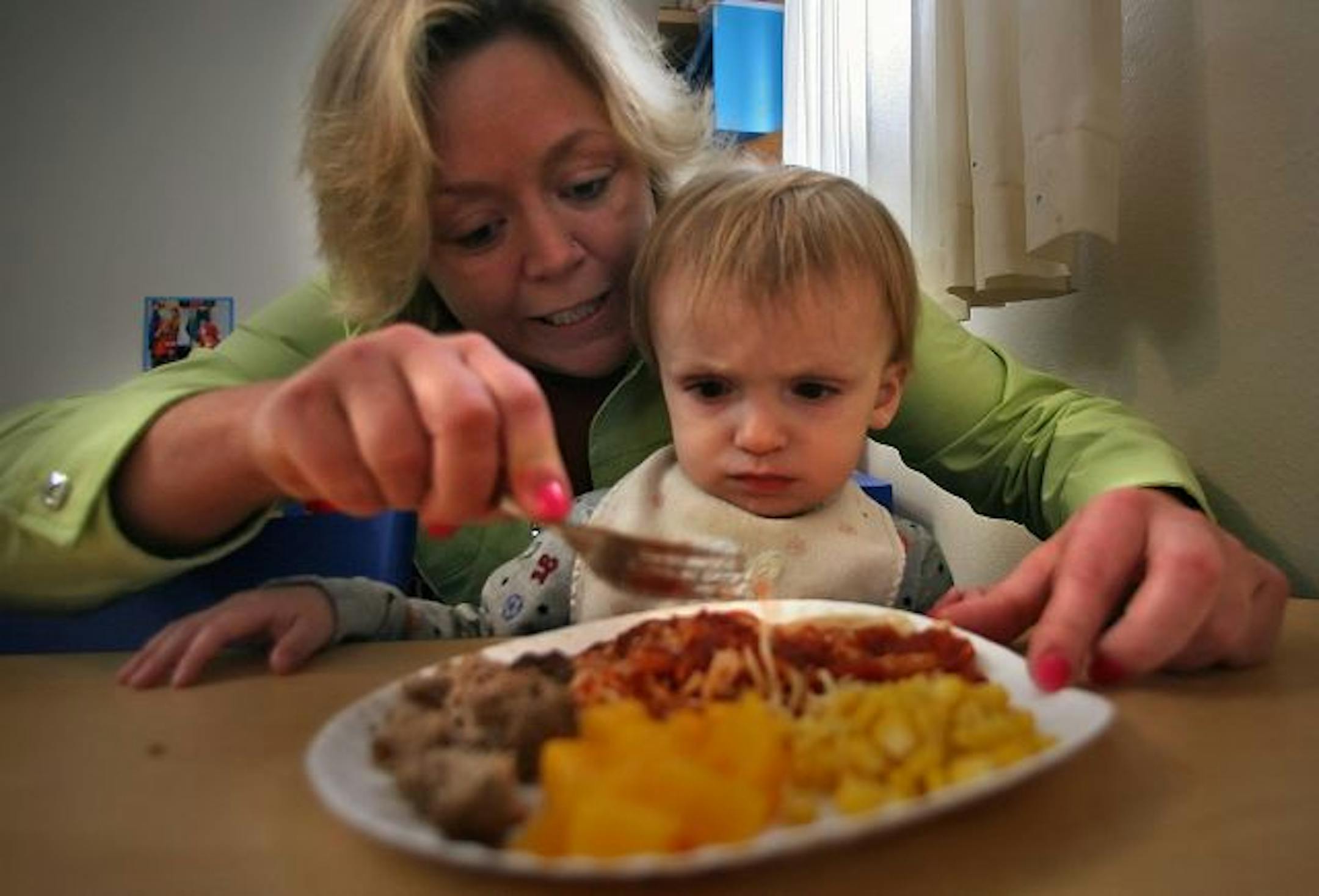 "I've lost five children in the past two months," said day care provider Penny Shepherd, who is trimming expenses for her day care kids and her own family. Here, Shepherd helped Kyler Koval during the lunch hour at her home in White Bear Lake.