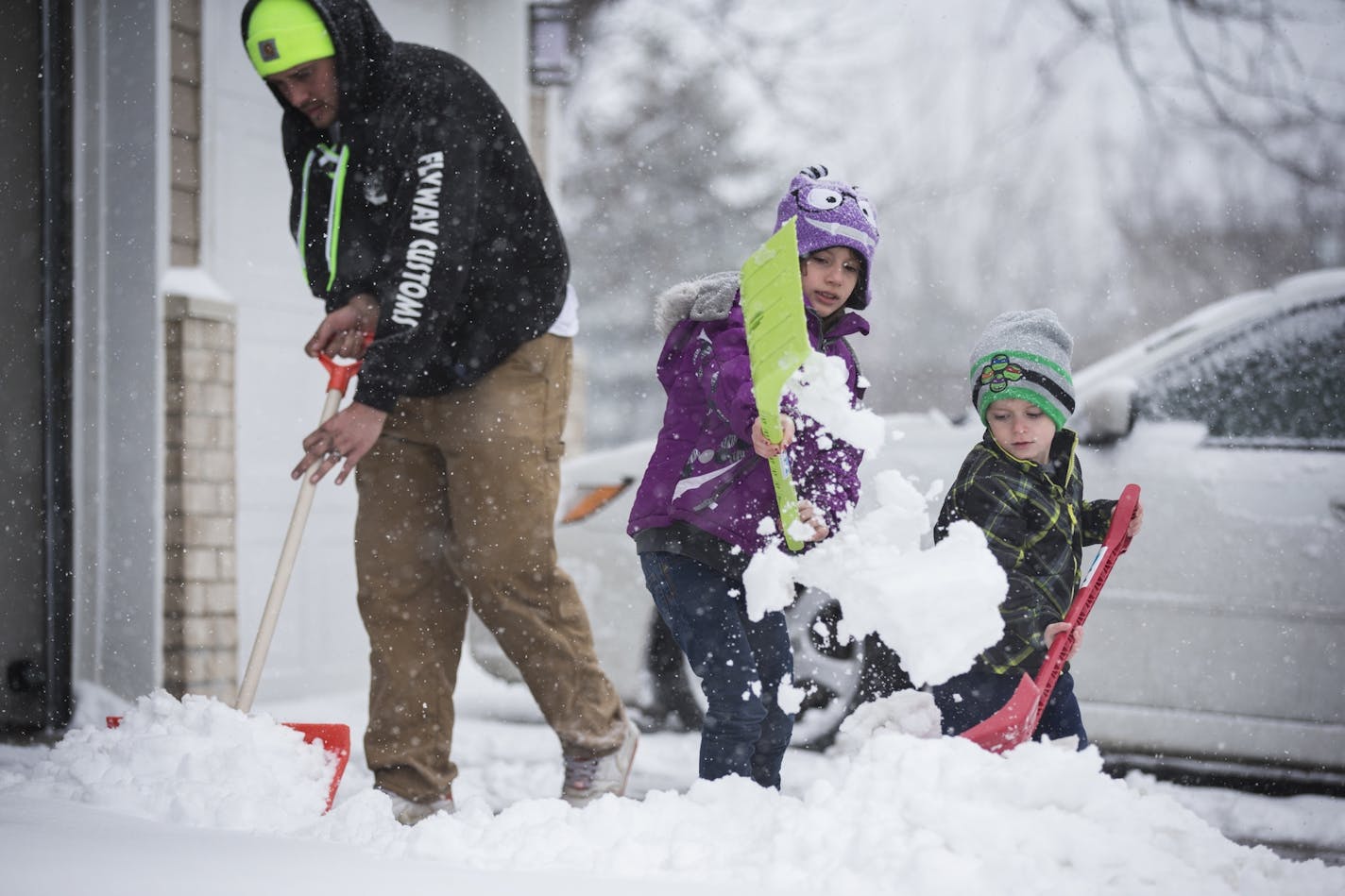 Cole Hammer, 4, and his big sister Isabella, 7, helped their father Nick to clear the driveway during an early spring snowstorm in Lakeville.