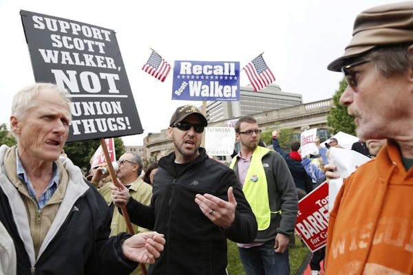 A supporter of Wisconsin Gov. Scott Walker, right, talks with a supporter of Democratic opponent Tom Barrett at a recall election rally Friday, June 1