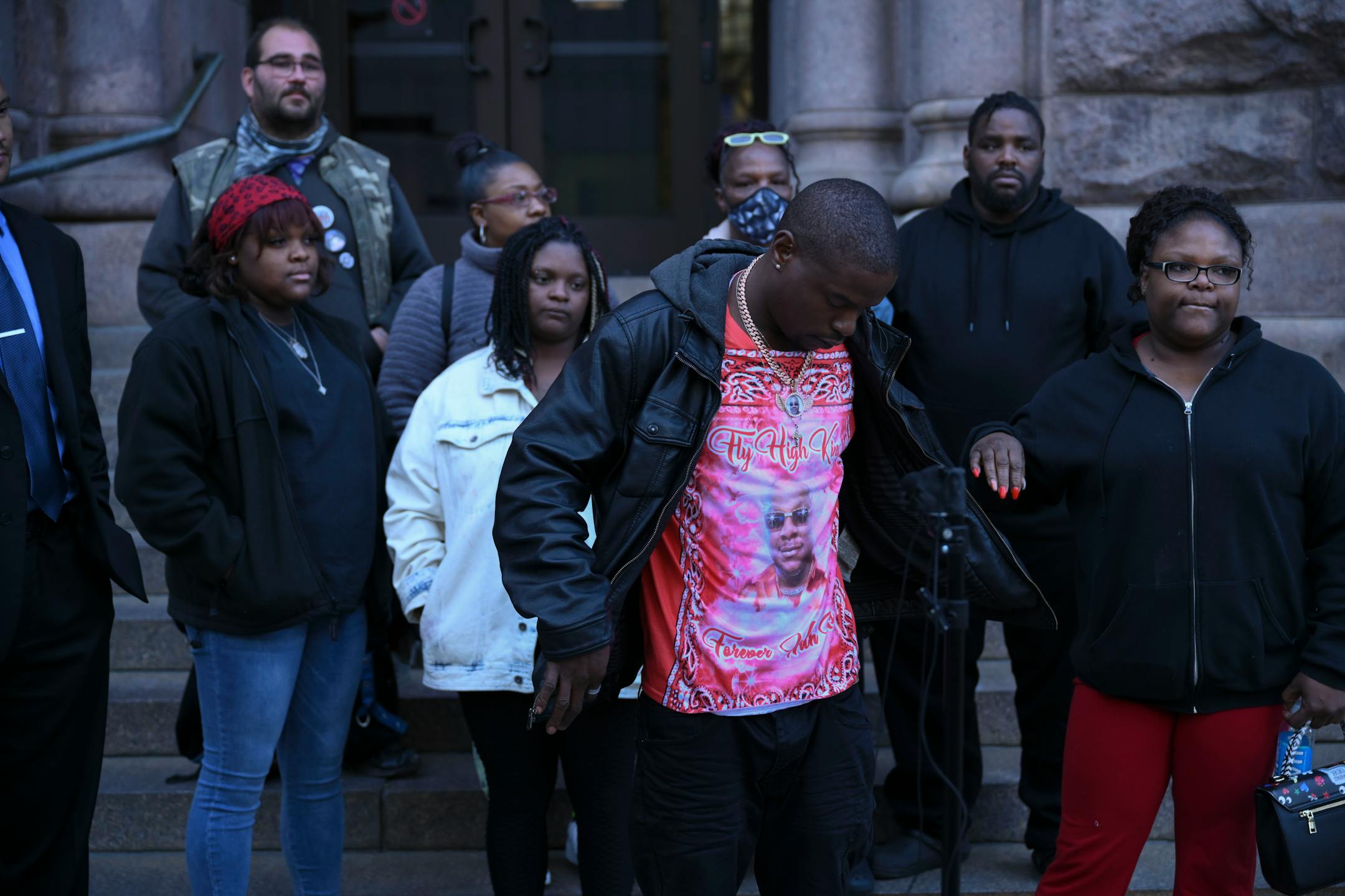 Orlando Frazier, brother of Leneal Frazier, shows a photo of his brother on his shirt as he speaks about Leneal's death and the court appearance of Minneapolis Police officer Brian Cummings during a news conference outside Minneapolis City Hall Tuesday, Nov. 9, 2021 in Minneapolis, Minn. Standing with Frazier is his family and attorneys Jeff Storms, right, and Christopher Scott. Minneapolis police officer Brian Cummings made his first appearance in court via zoom Tuesday for striking a vehicle and killing the driver, Leneal Frazier, during a pursuit through in July, 2021. ] AARON LAVINSKY • aaron.lavinsky@startribune.com
