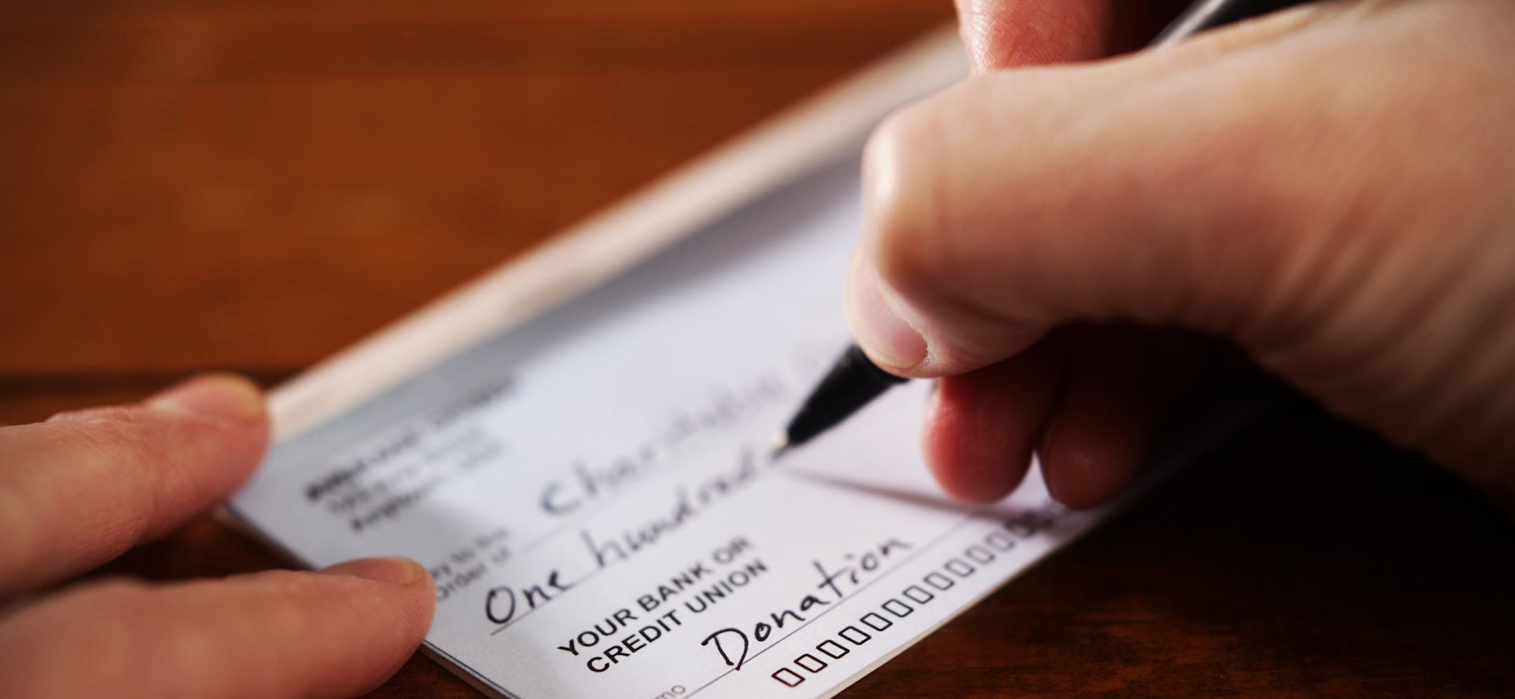 iStock
Writing a donation check to a charitable organization.