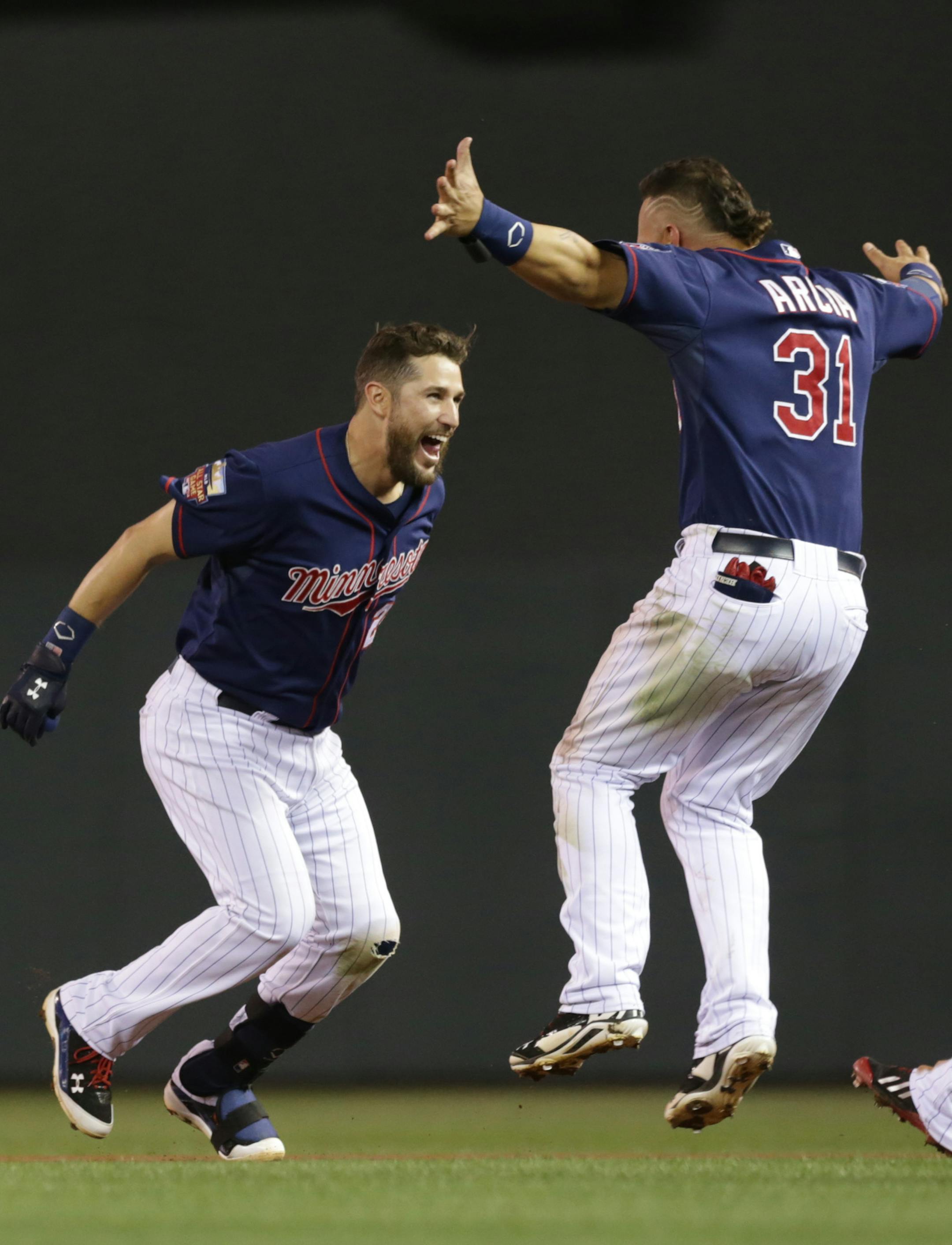 Minnesota Twins' Oswaldo Arcia, right, races in to congratulate Trevor Plouffe on his walk-off single off Cleveland Indians pitcher Josh Tomlin in the 10th inning of a baseball game, Friday, Sept. 19, 2014, in Minneapolis. The Twins won 5-4. (AP Photo/Jim Mone)