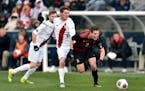 Stanford's Foster Langsdorf is knocked off the ball by Indiana' Trevor Swartz during the second half of the NCAA College Cup championship soccer match