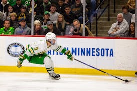 Edina forward Mason West reaches to control the puck during the first period Saturday.