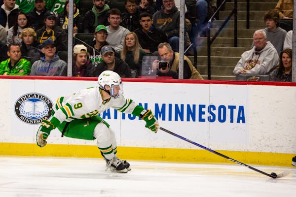 Edina forward Mason West reaches to control the puck during the first period Saturday.