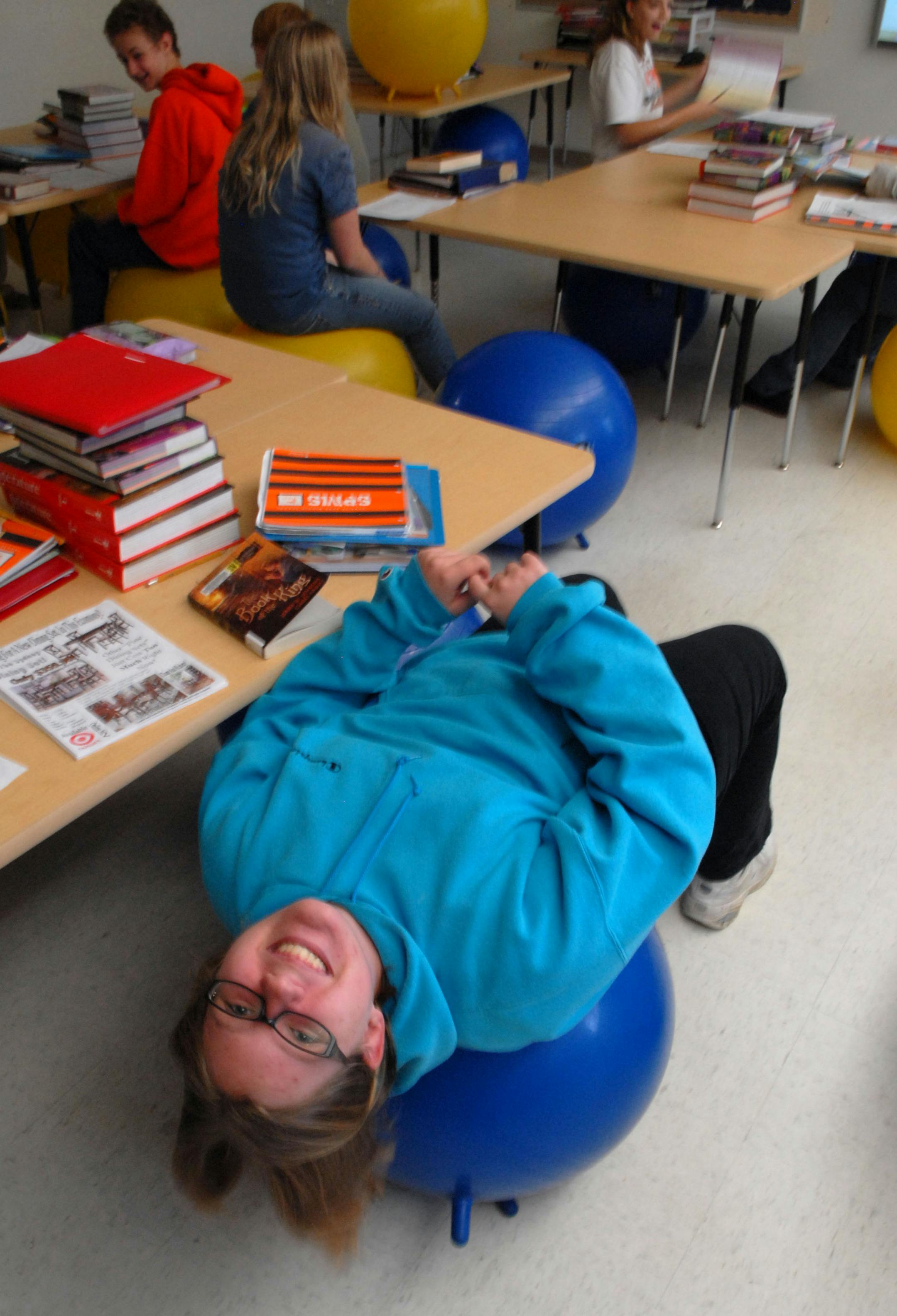 Stephani Lassila occassionaly leans way back while streching out . BALANCE: The kids in Melisa Tennant�s seventh grade English class at Sunrise Park Middle School in White Bear Lake are giving new meaning to being �on the ball.� All 140 kids she teaches in five classes now use the balance balls instead of traditional desks. While it�s not the first time for balance balls in classrooms � educators and therapists have suggested them previously for younger children who exhibit forms of attention de