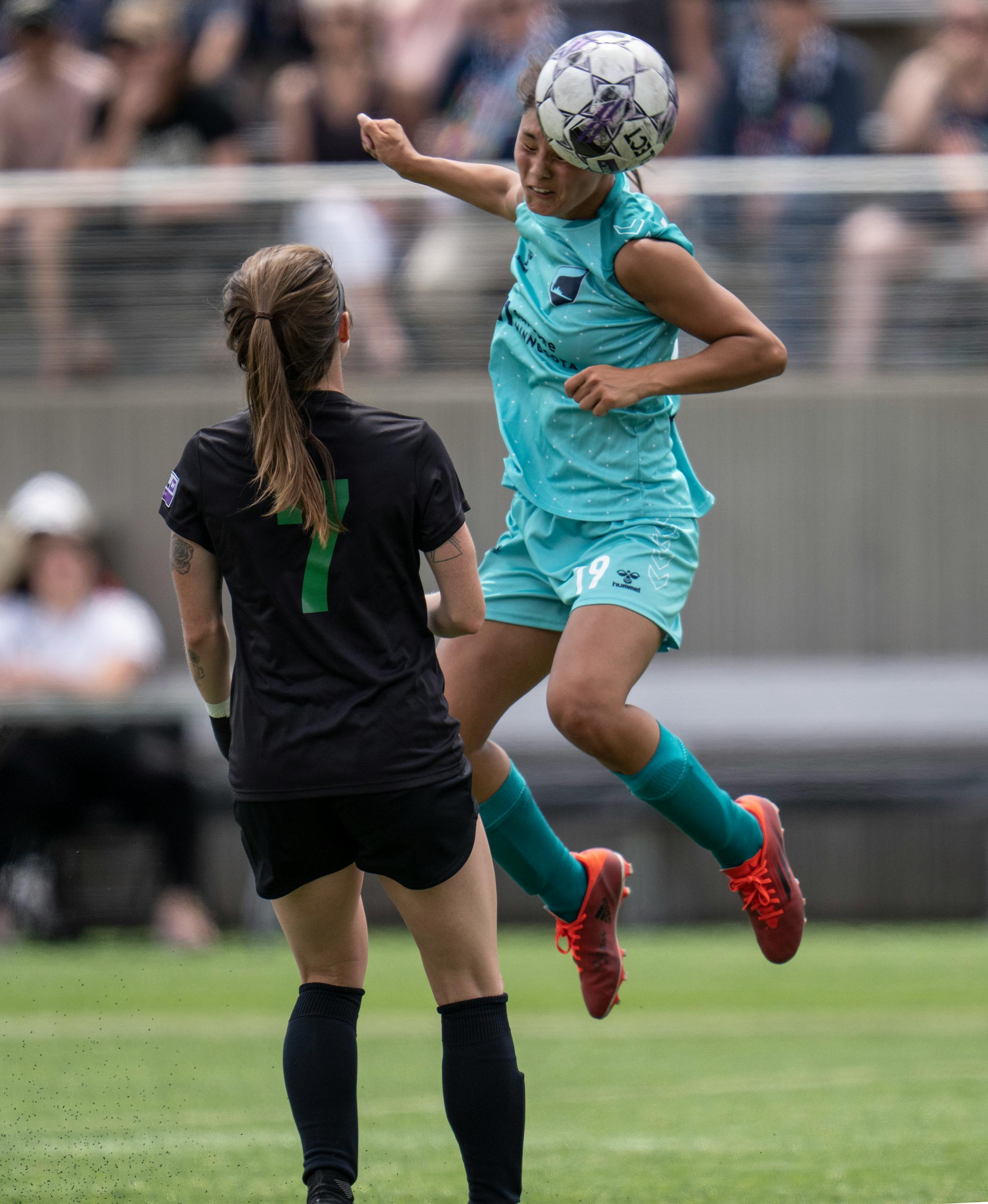 Minnesota' Mariah Nguyen, headed the ball away from St. Louis' Kierstyn Weaver in the first half.
