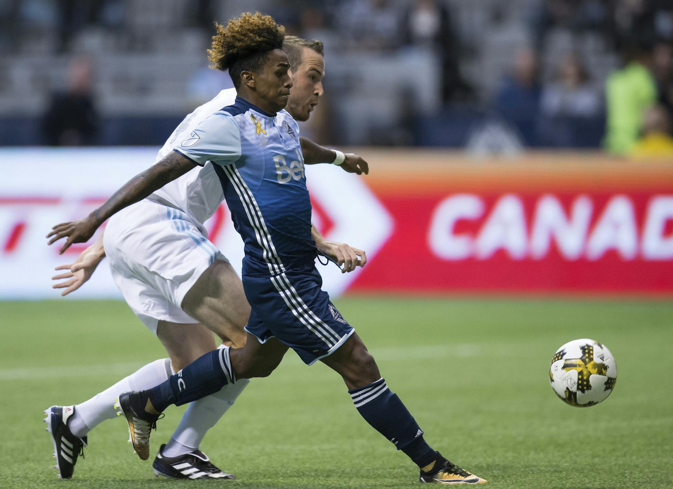 Vancouver Whitecaps' Yordy Reyna, front, scores a goal as Minnesota United's Brent Kallman defends during the first half of an MLS soccer match Wednesday, Sept. 13, 2017, in Vancouver, British Columbia. (Darryl Dyck/The Canadian Press via AP)