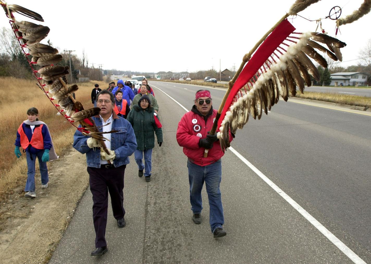 Carrying eagle-feather flags Glenn Wasicuna, of Prior Lake, , left, and Bear, of Lamedeer, Montana lead the group of walkers and the caravan of cars behind them during the Dakota Commemorative March Wednesday afternoon. This is to honor the 1,000 Dakota people who were forced to march 150 miles from their reservation to Fort Snelling in 1862.
GENERAL INFORMATION: Wednesday, November 13, 2002-Shakopee-The `Dakota Commemorative March,' an observance by descendants of the forced march of 1,000 Siou