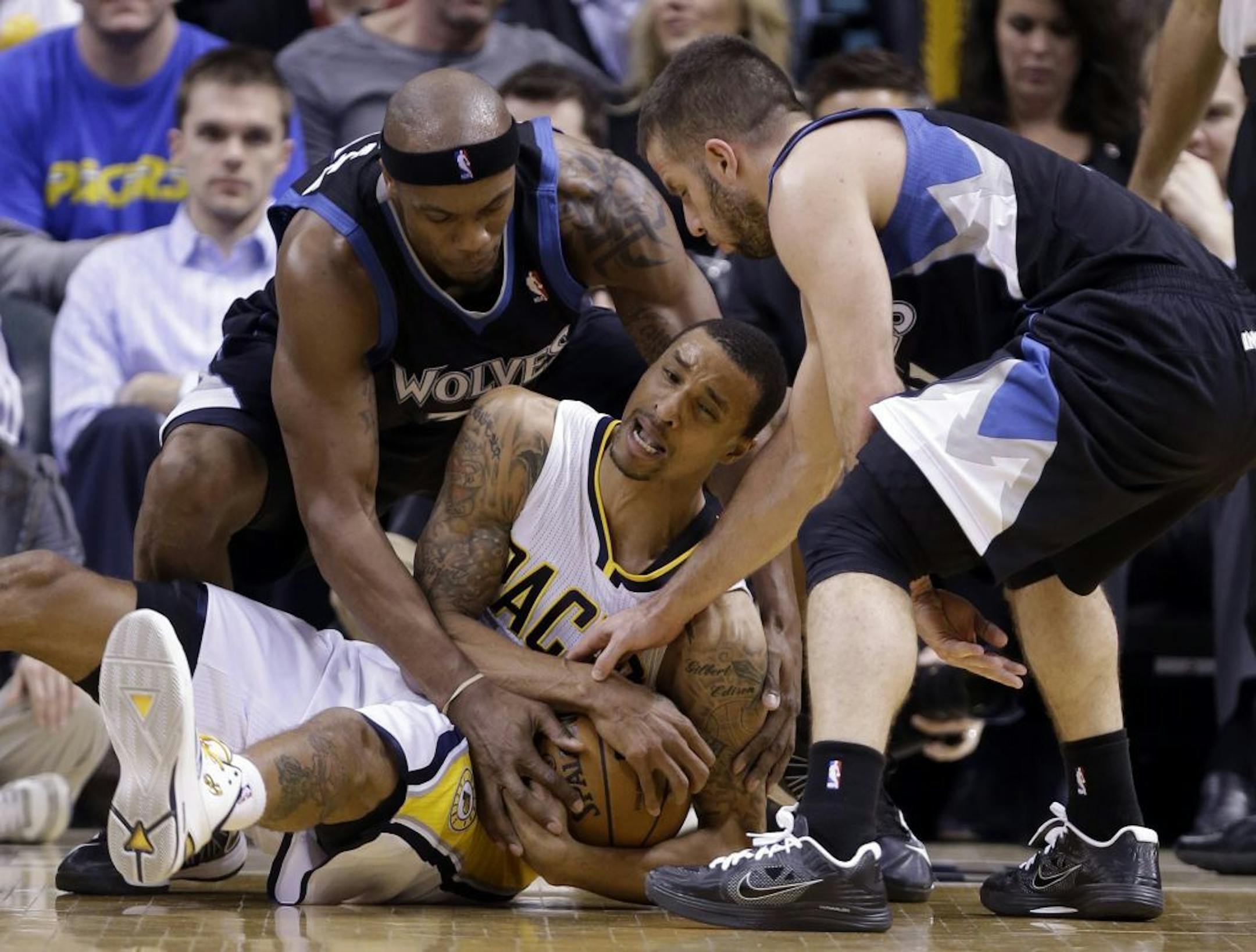 Pacers guard George Hill, center, gets tied up with Minnesota Timberwolves guard J.J. Barea, right, and forward Dante Cunningham.