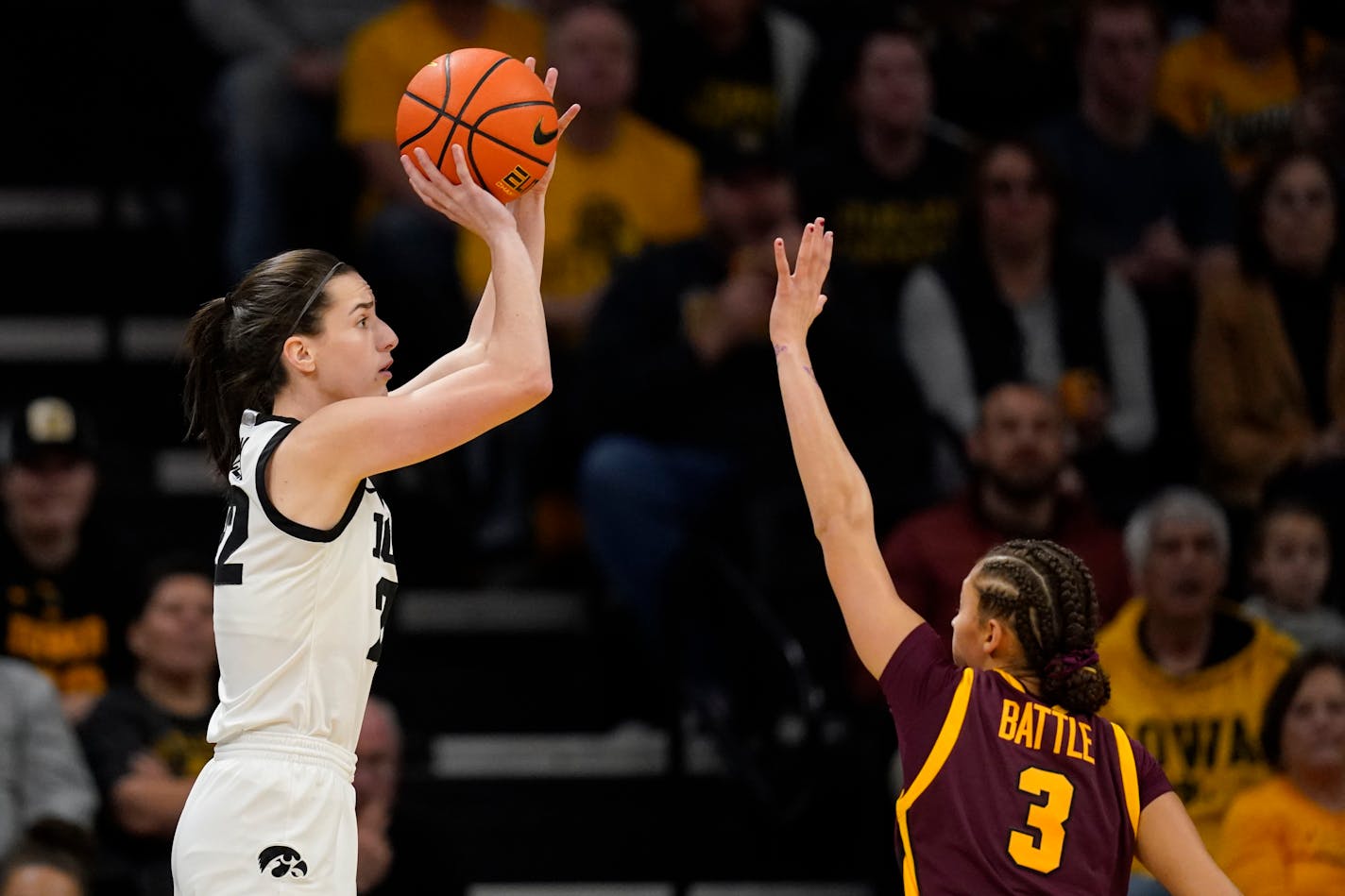 Iowa guard Caitlin Clark put up a shot over Gophers guard Amaya Battle during the first half Saturday in Iowa City.