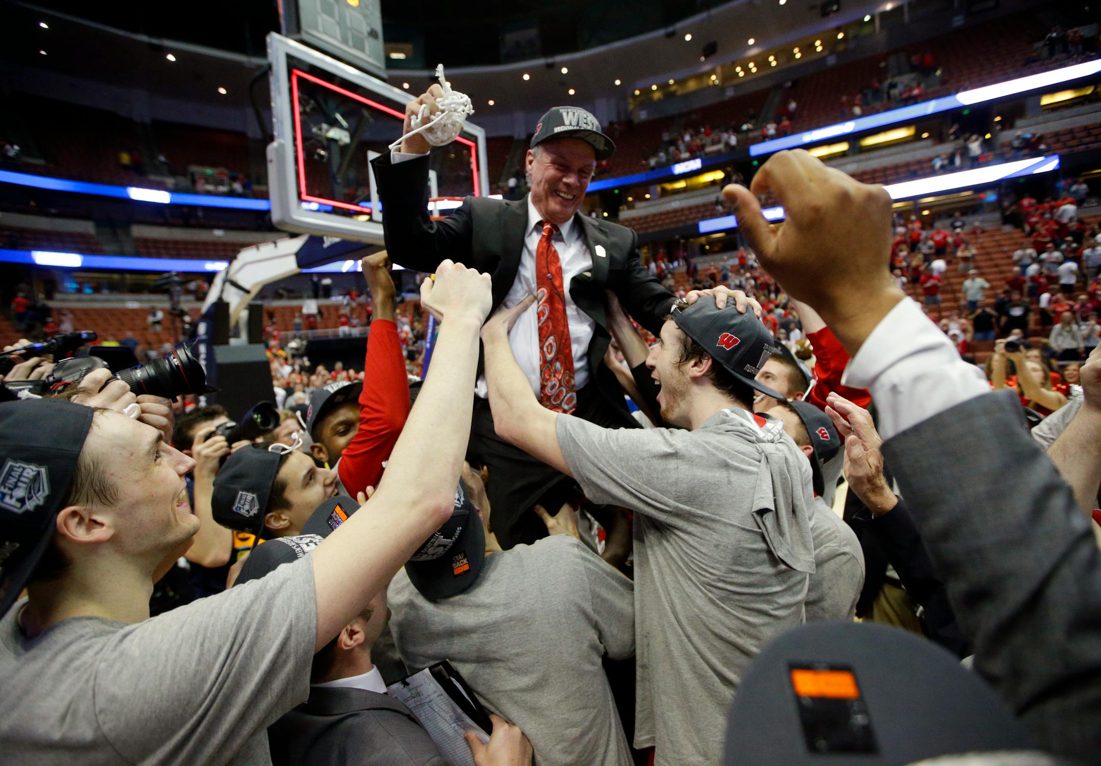 Players lift Wisconsin head coach Bo Ryan after a regional final NCAA college basketball tournament game against Arizona, Saturday, March 29, 2014, in Anaheim, Calif. Wisconsin won 64-63 in overtime. (AP Photo/Jae C. Hong)