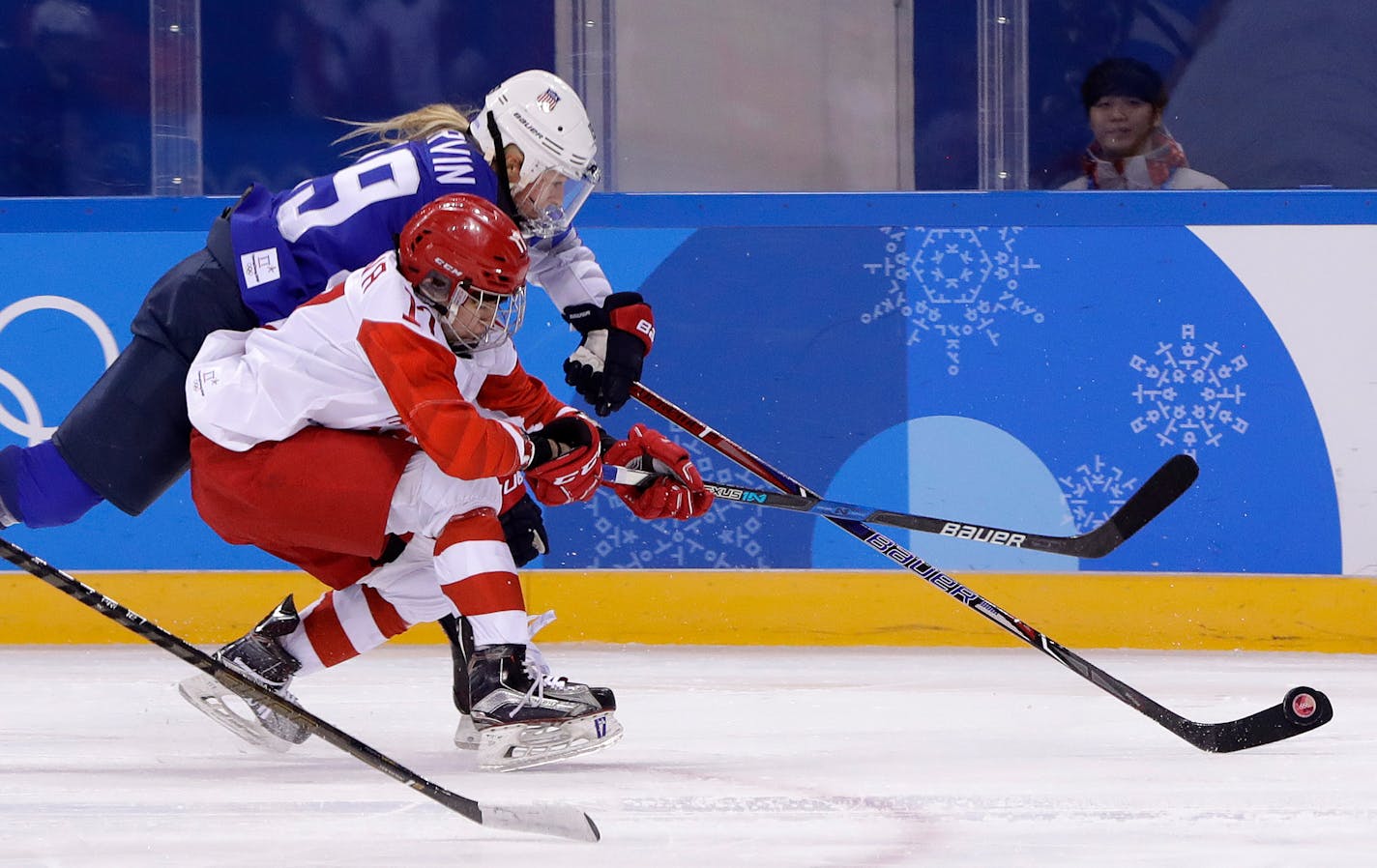 Gigi Marvin (19), of the United States, and Russian athlete Fanuza Kadirova (17) battle for the puck during the third period of the preliminary round of the women's hockey game at the 2018 Winter Olympics in Gangneung, South Korea, Tuesday, Feb. 13, 2018. (AP Photo/Matt Slocum)