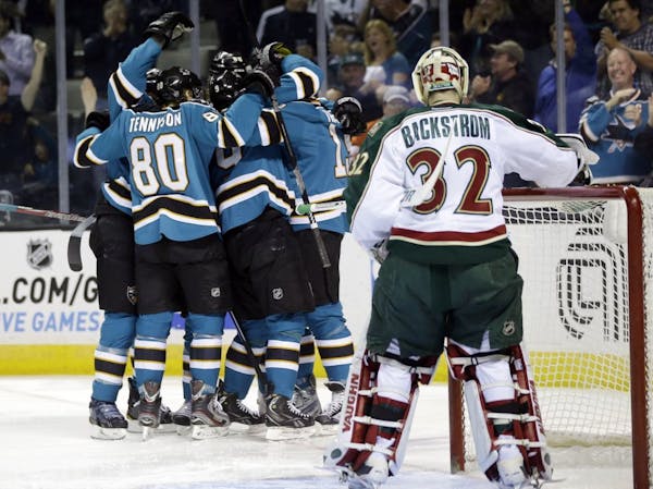 Wild goalie Niklas Backstrom watches as the San Jose Sharks celebrate a goal by Martin Havlat during the first period