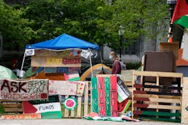 FILE - A student walks in a pro-Palestinian encampment at Main Quadrangle on the University of Chicago campus Monday, May 6, 2024, in Chicago.