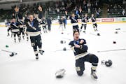 Chanhassen players, including forward Tyler Smith (16) and defenseman Ben Curtis (21), celebrate their 2-1 win over Minnetonka in the section final.