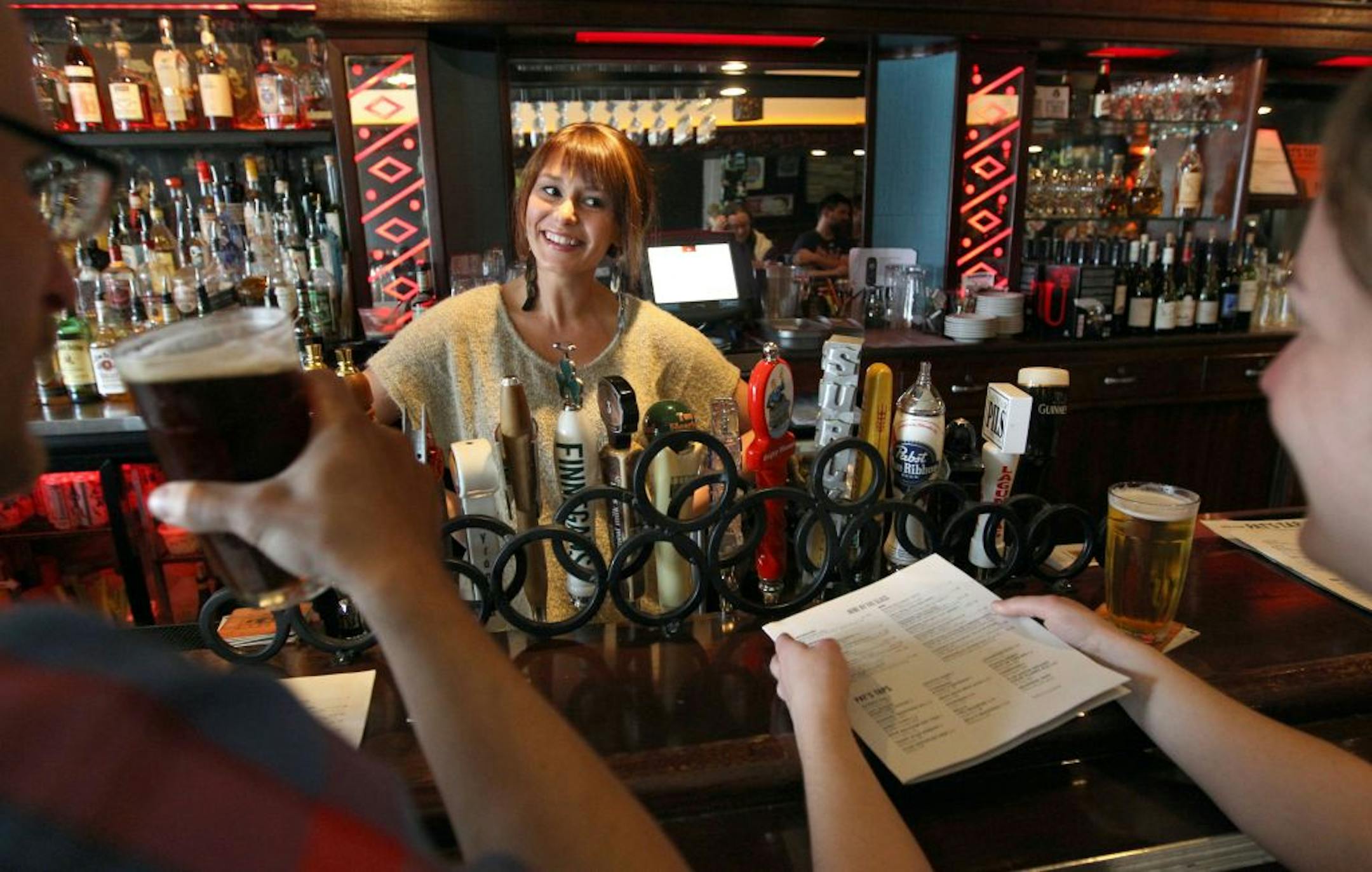 Barkeep, Katie Meehan chats with customers, Darren Ceckanowicz and Rebecca Bombyk after serving them up a couple of beers. Review of Pat's Tap, 3510 Nicollet Ave South, Chef Charlie Schwandt Food: Vegetable curry, bacon burger, cold cuts plate, Buffalo Chicken Terrine. [ TOM WALLACE • twallace@startribune.com _ Assignments #20022785A _ March 29, 2011_ SLUG: rn0405_ EXTRA INFORMATION: